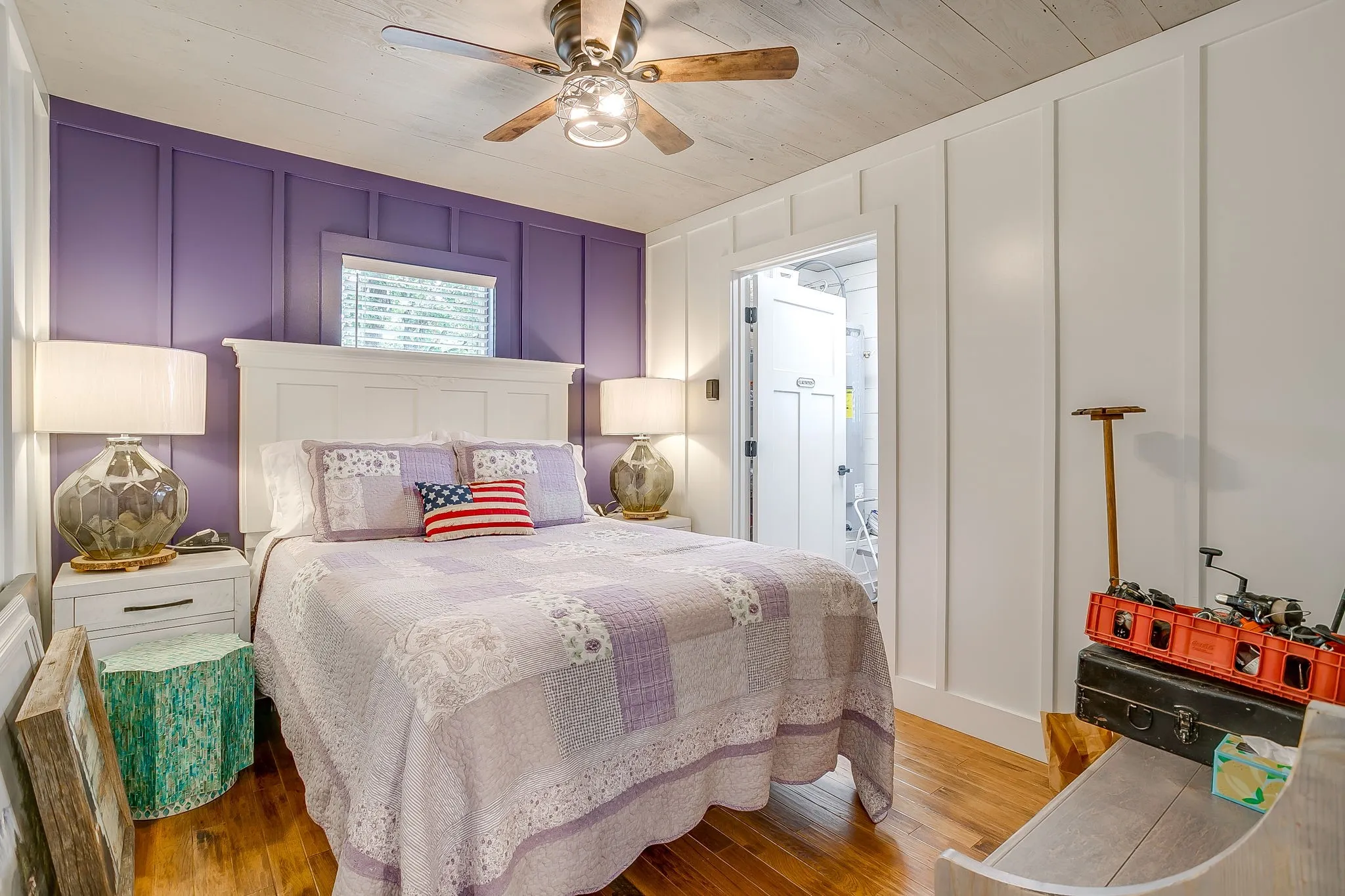 Bedroom featuring a decorative wall, light wood-type flooring, and a ceiling fan