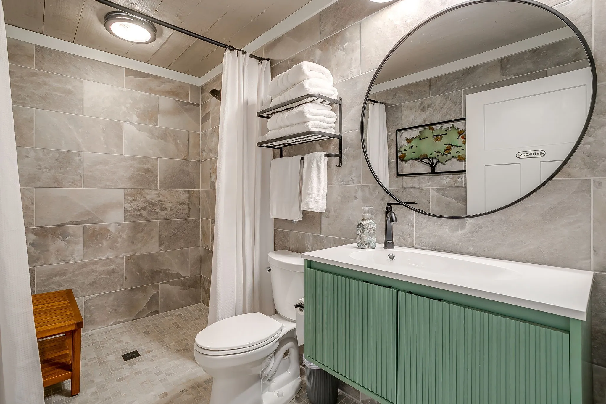 Full bathroom with tile walls, vanity, and a tile shower