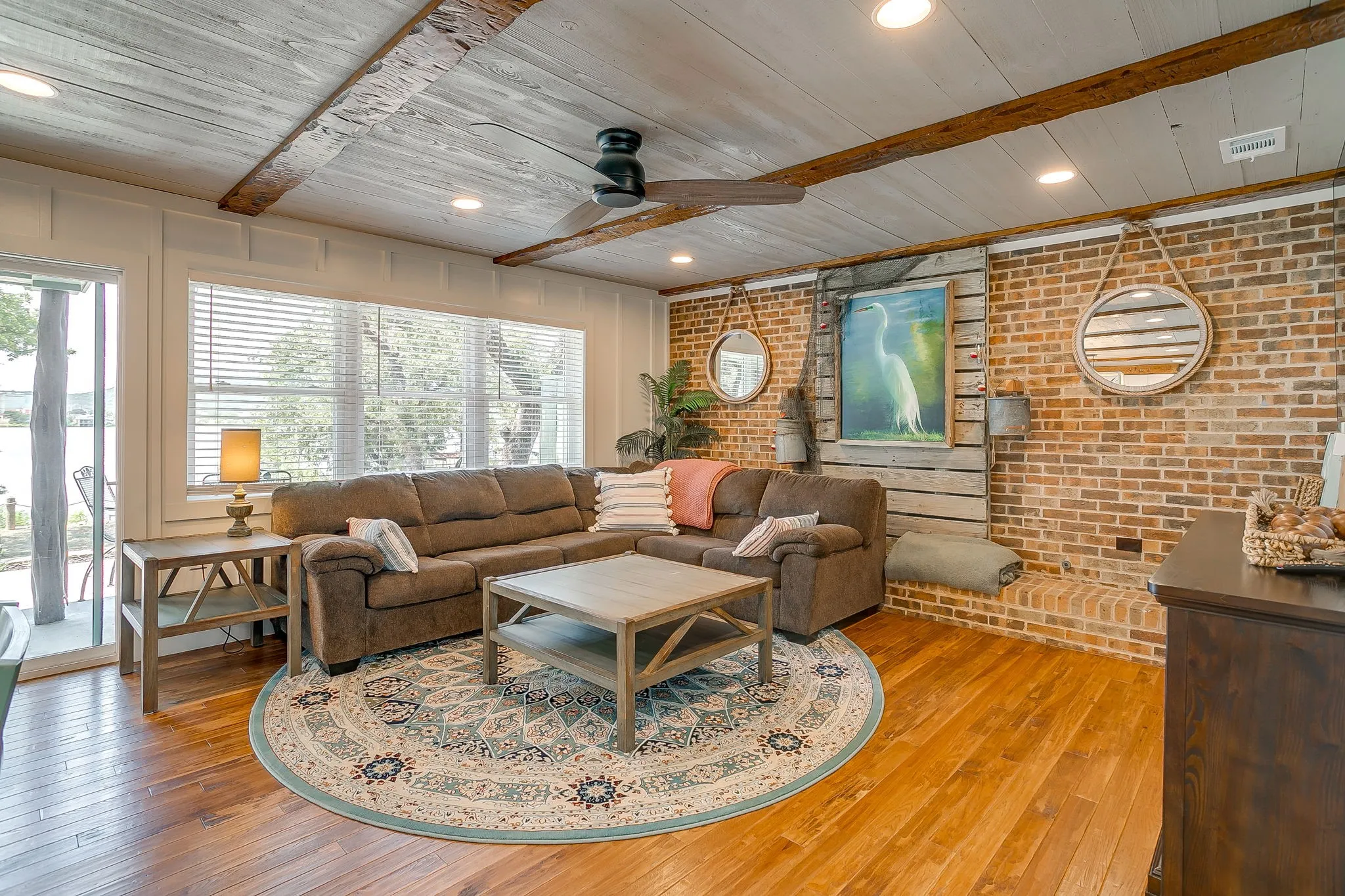 Living room featuring recessed lighting, wood-type flooring, brick wall, a wooden ceiling with exposed beams, and ceiling fan