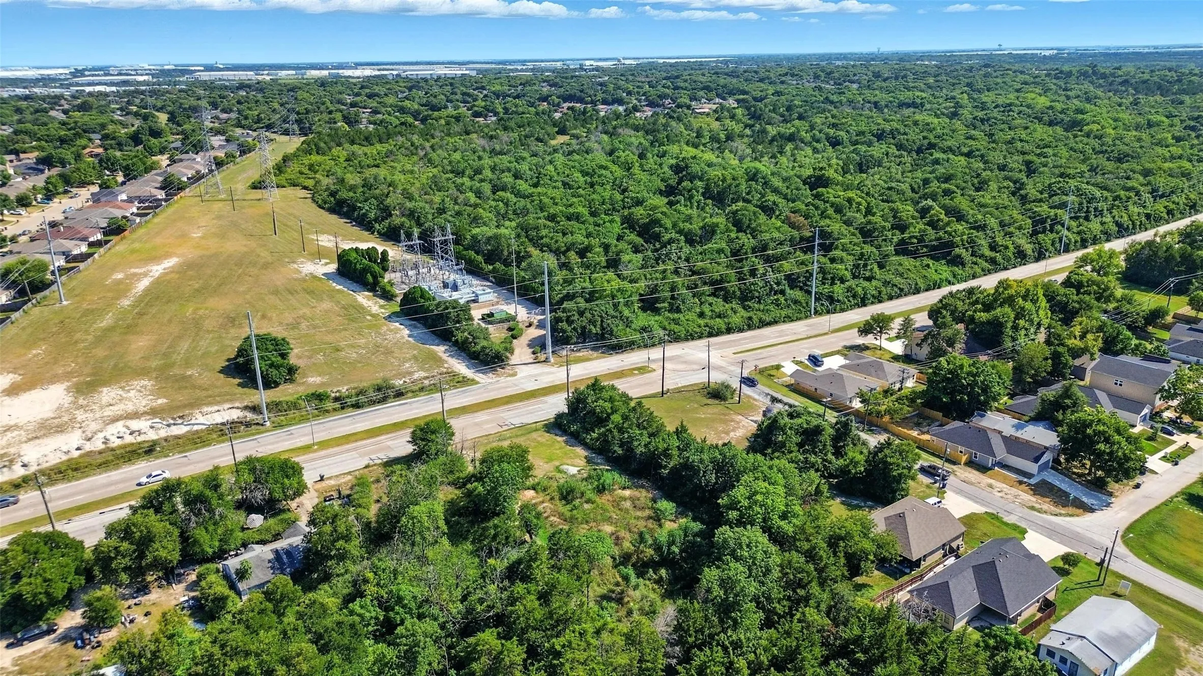 Aerial perspective of suburban area featuring a heavily wooded area