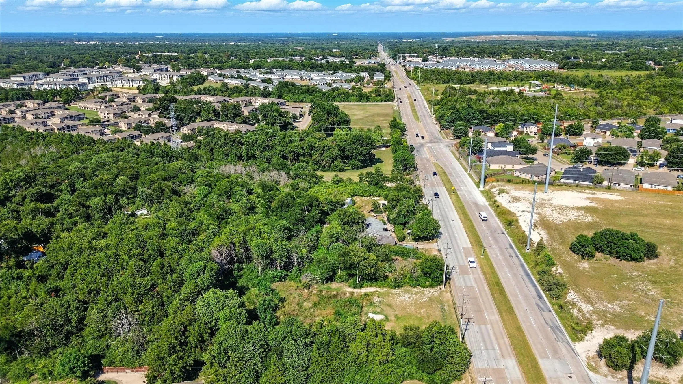 Aerial view of property's location with a tree filled landscape