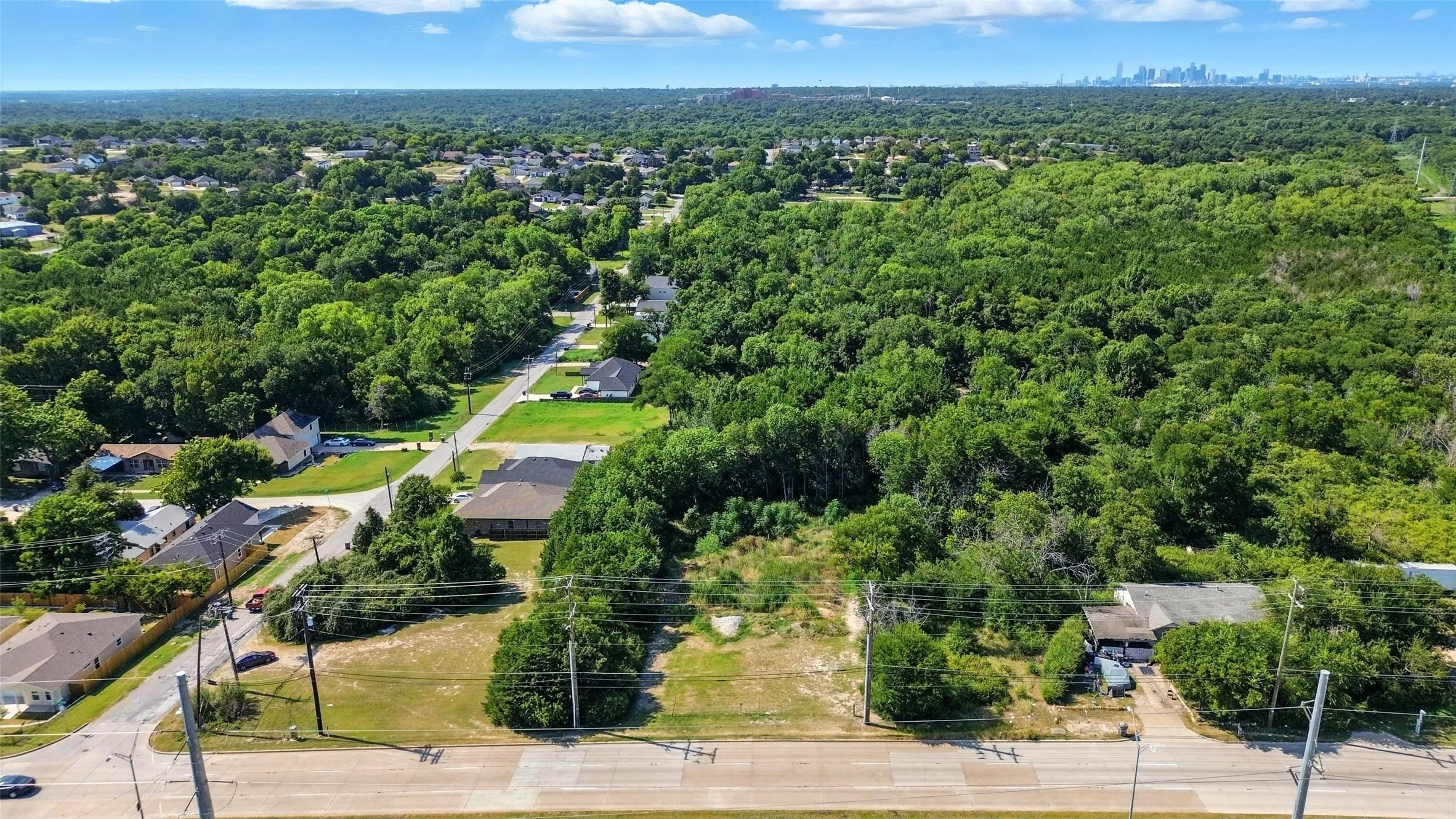 Aerial perspective of suburban area featuring a heavily wooded area
