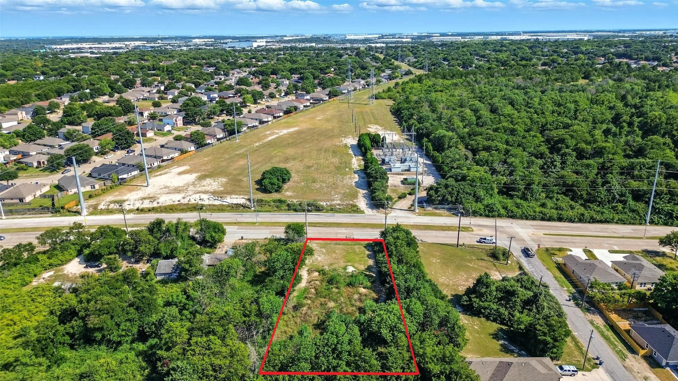 Aerial perspective of suburban area with property boundaries highlighted and a tree filled landscape