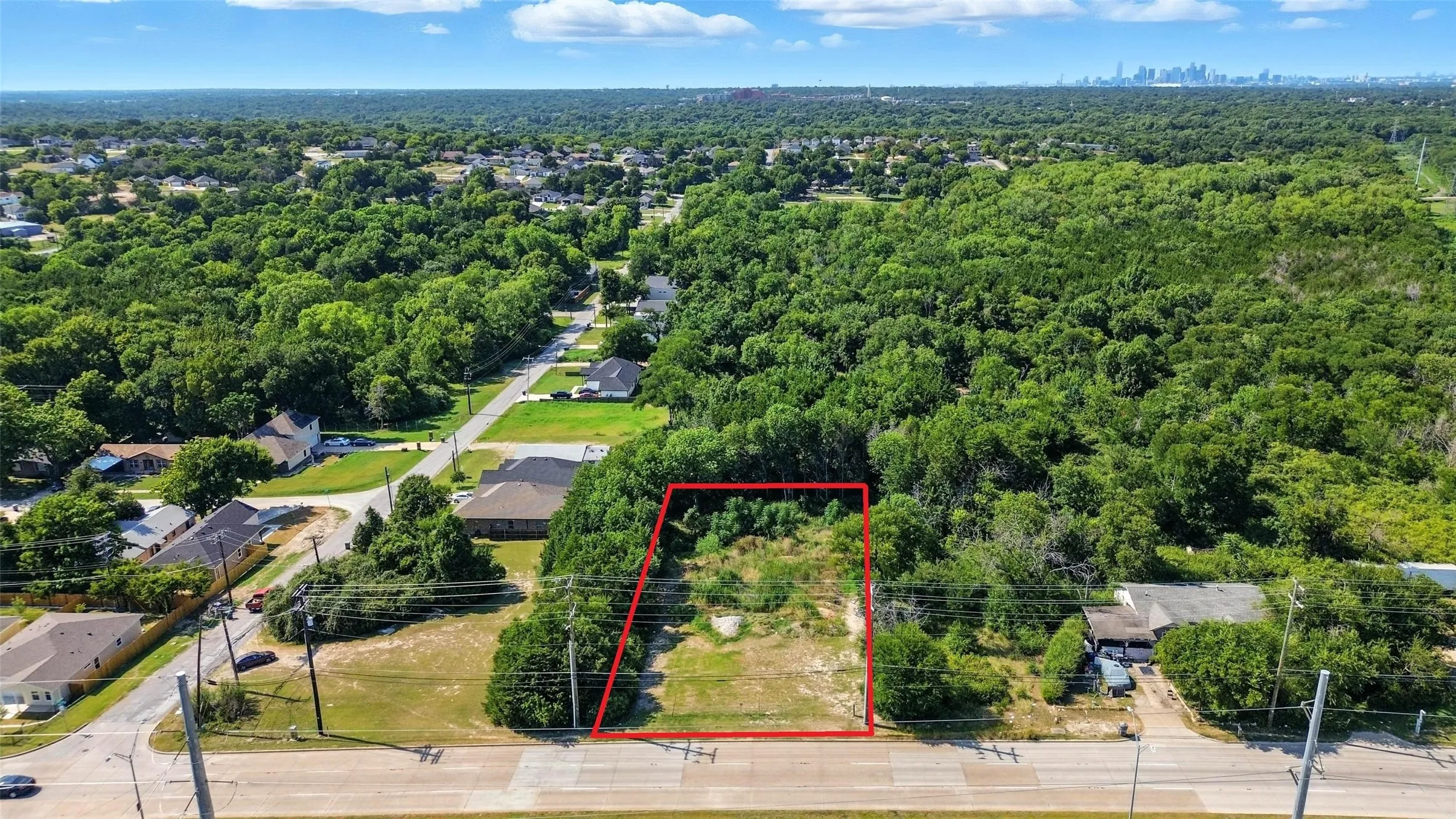 Aerial perspective of suburban area with property boundaries highlighted and a forest