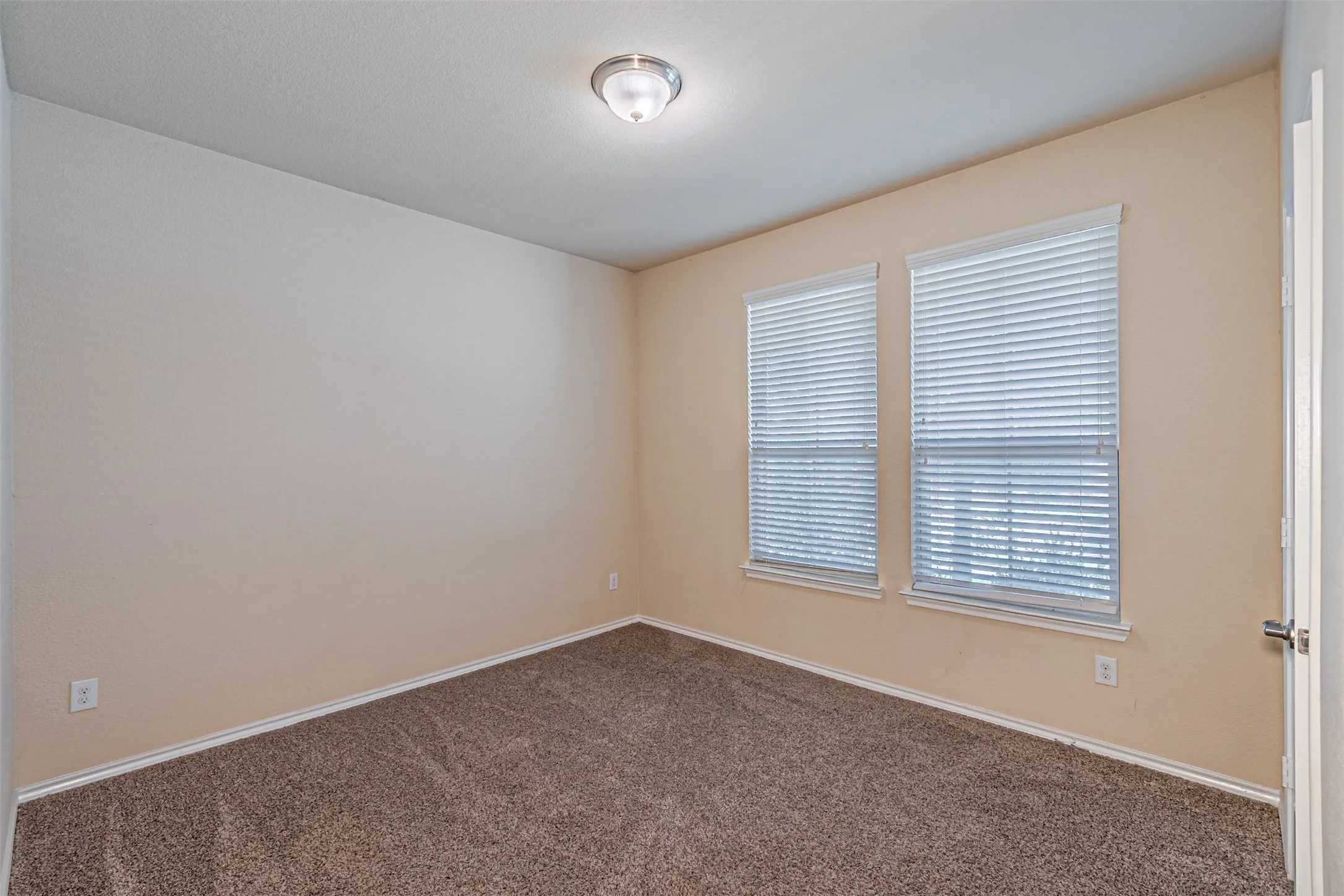 Spare room featuring carpet flooring and baseboards
