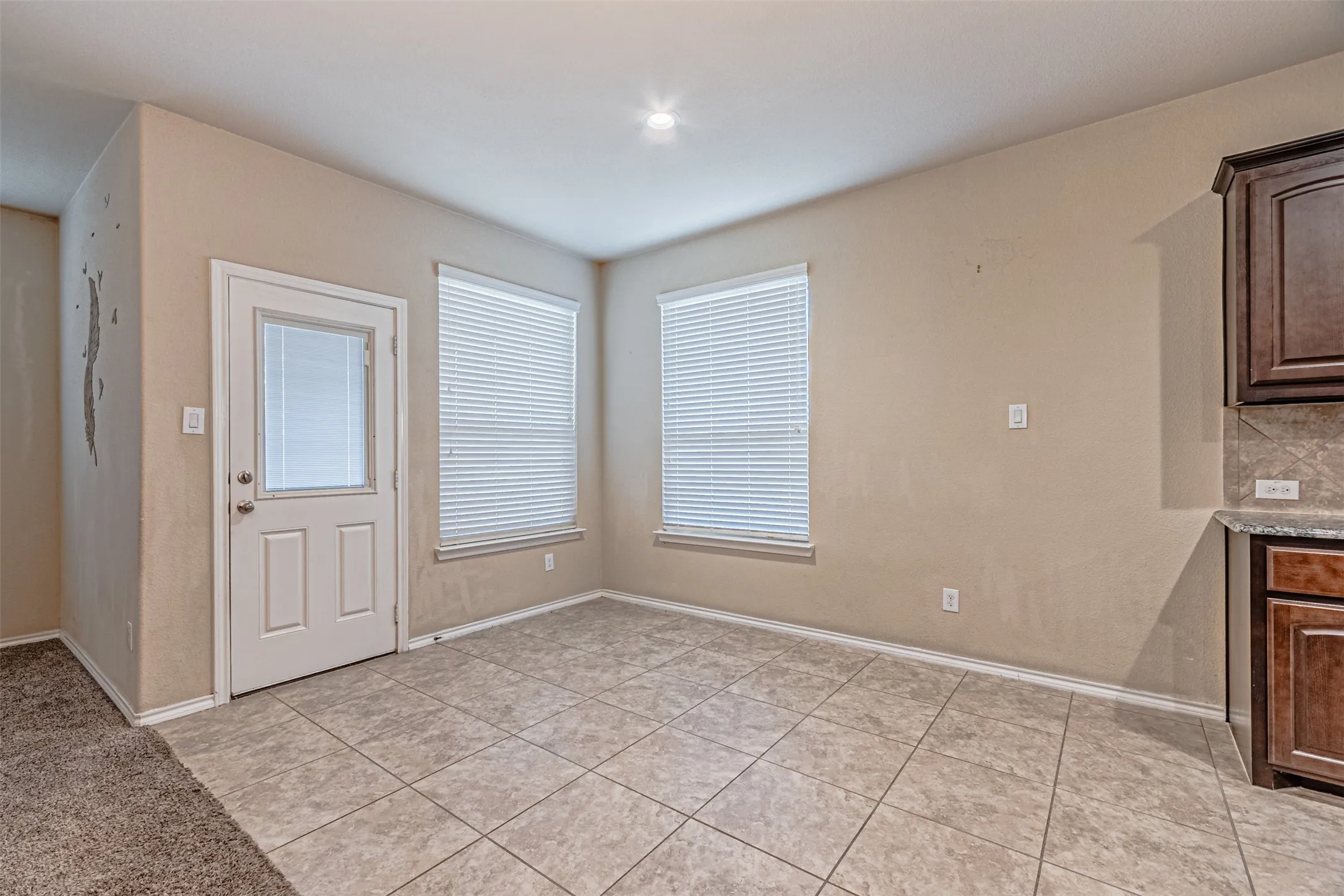 Unfurnished dining area featuring baseboards and light tile patterned floors