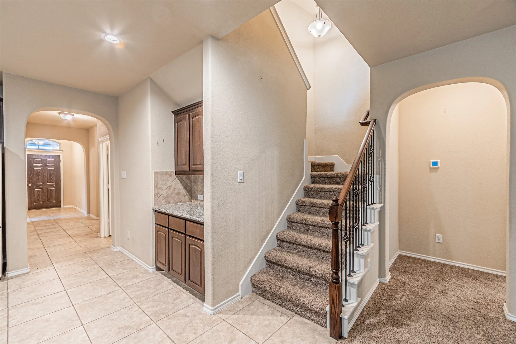 Stairs with arched walkways and tile patterned floors
