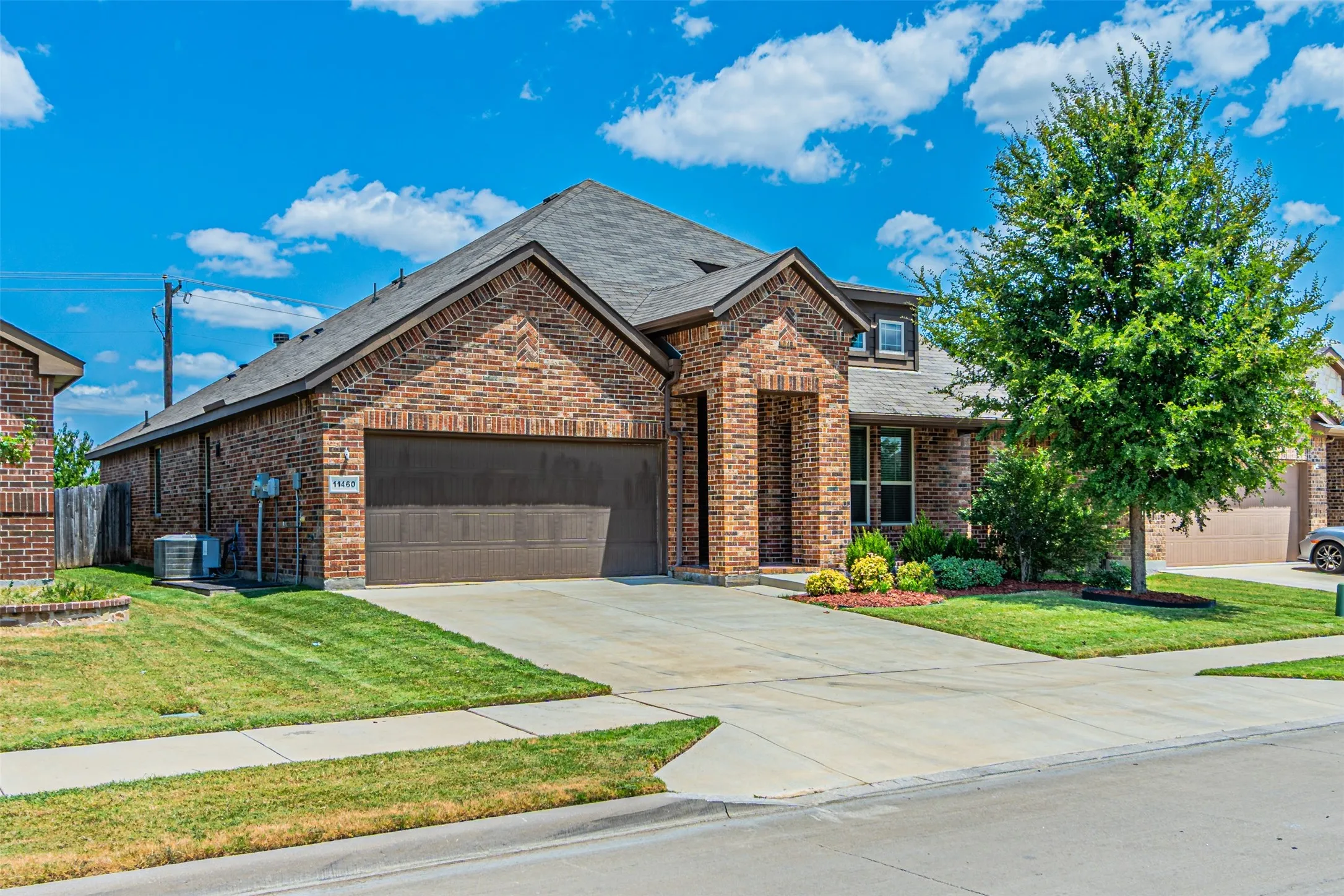 View of front facade featuring concrete driveway, a garage, a shingled roof, and a front yard
