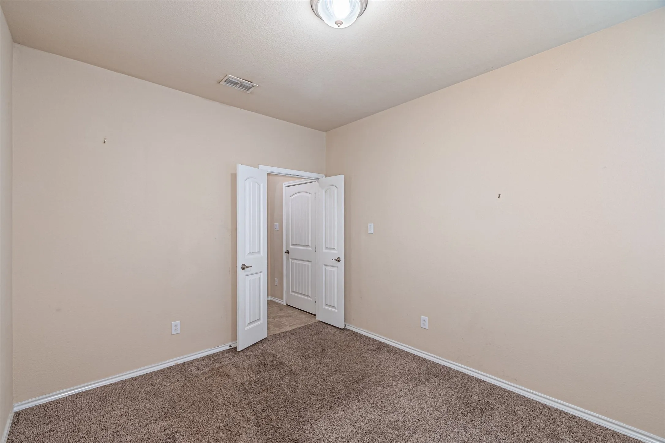 Carpeted spare room with baseboards