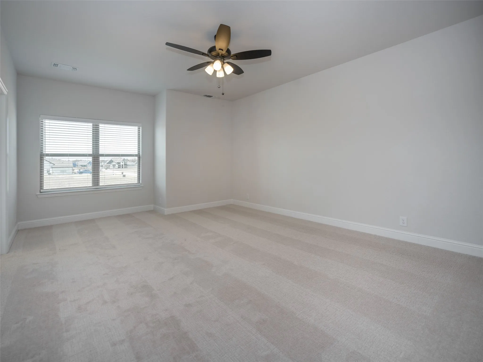 Unfurnished room with light colored carpet and ceiling fan