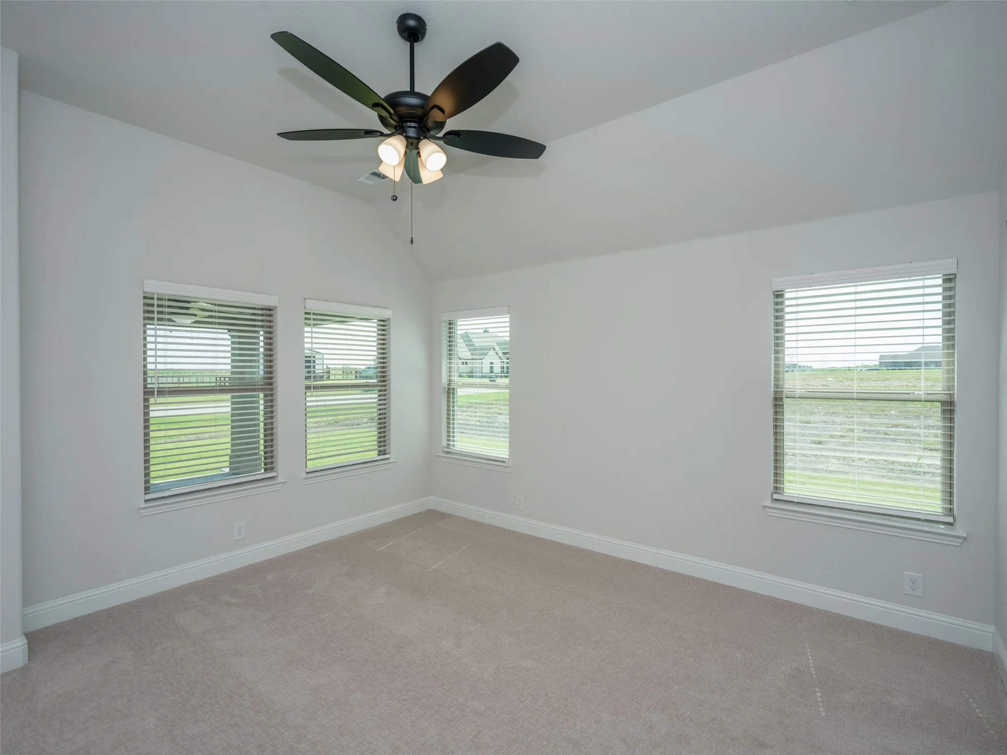 Unfurnished room with carpet flooring, lofted ceiling, and ceiling fan