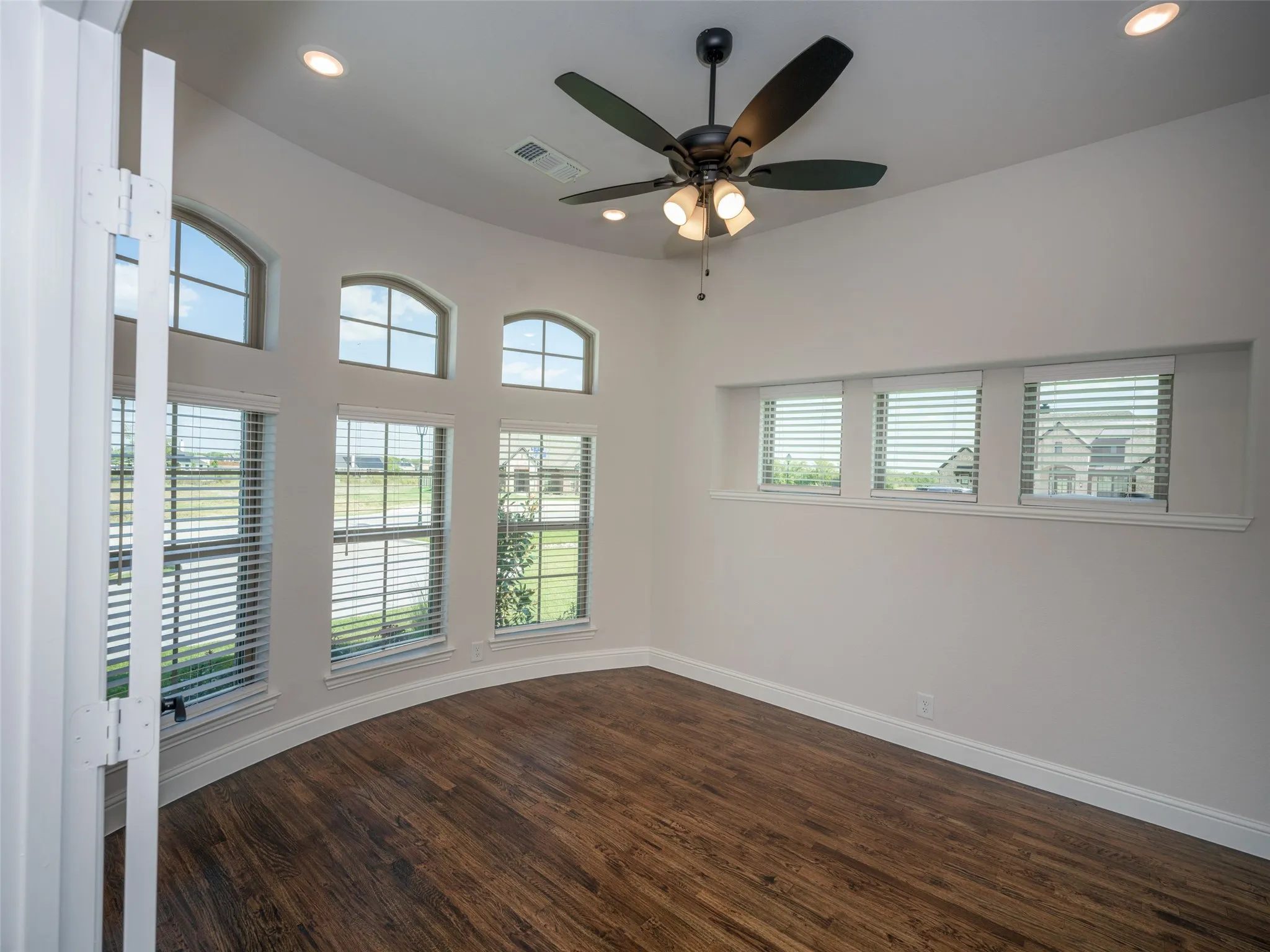 Empty room featuring dark wood finished floors, recessed lighting, and a ceiling fan