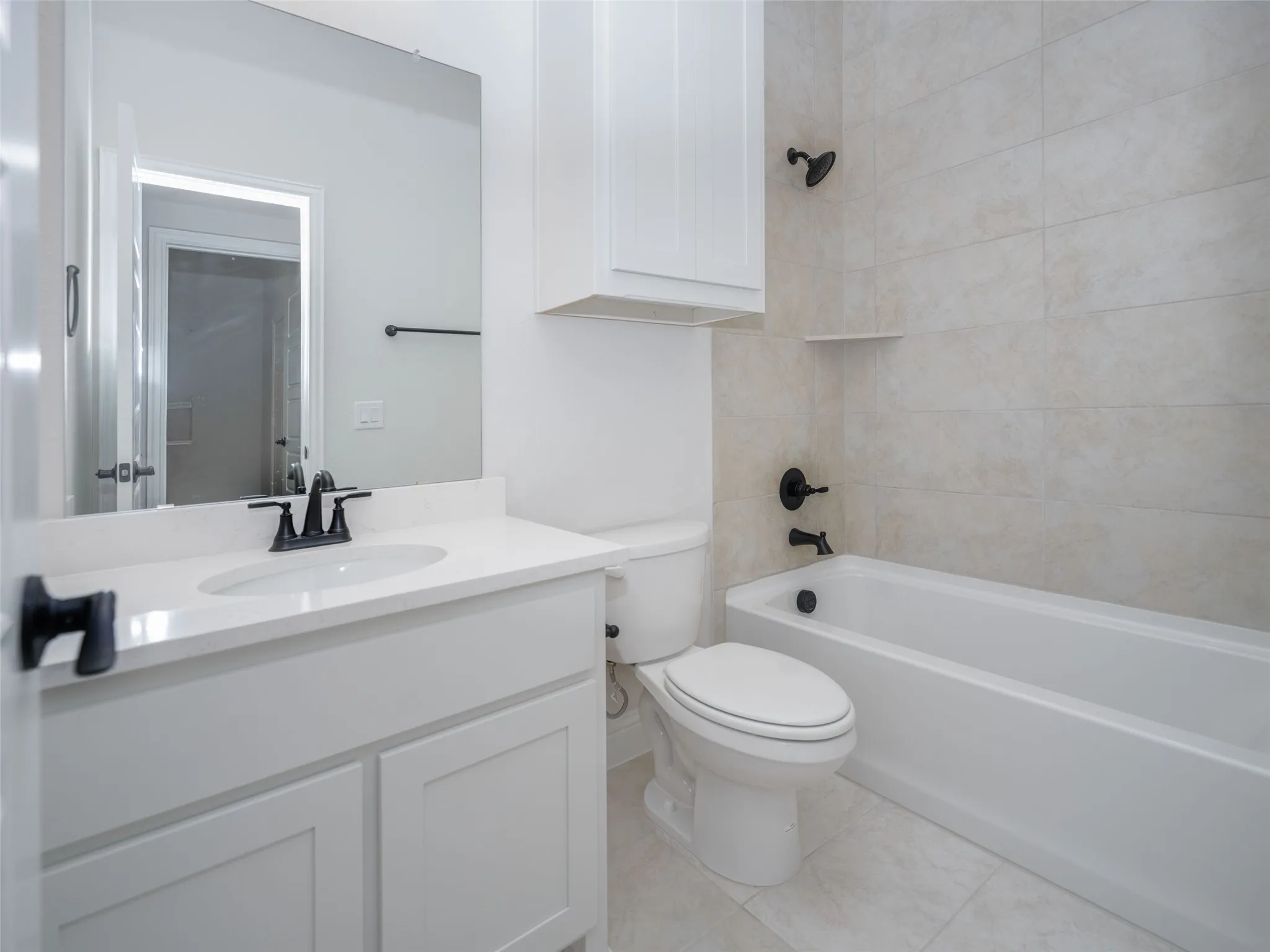 Full bathroom featuring bathtub / shower combination, vanity, and light tile patterned floors