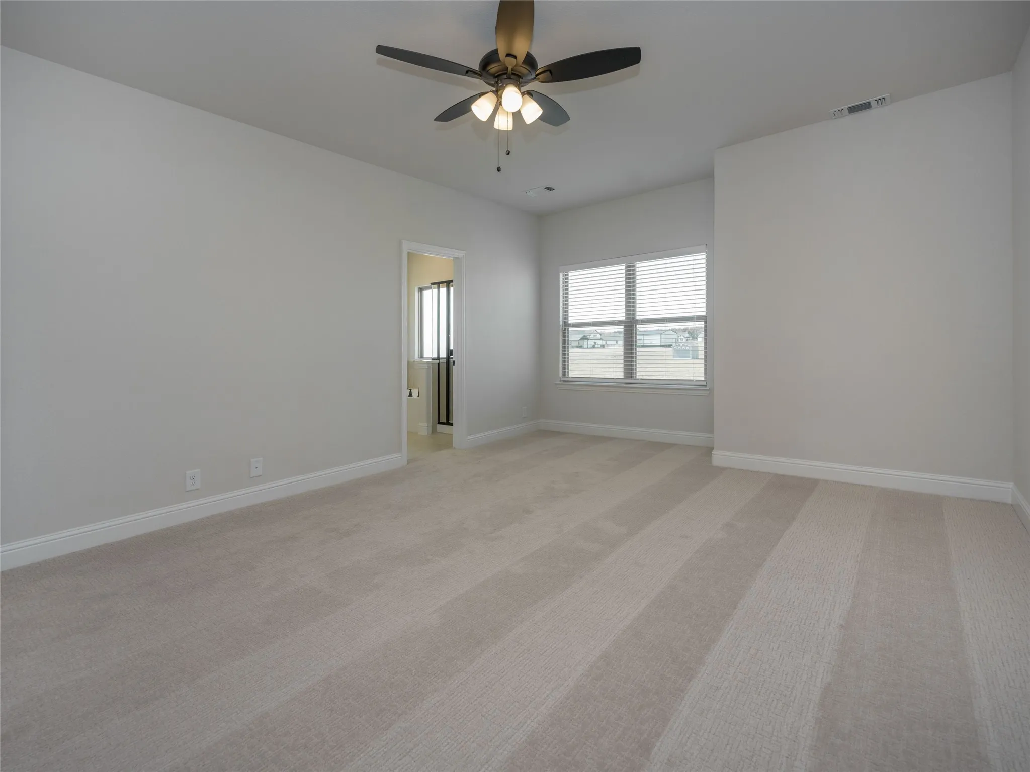 Spare room featuring light carpet and a ceiling fan