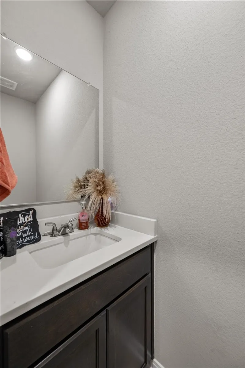 Bathroom with a textured wall and vanity