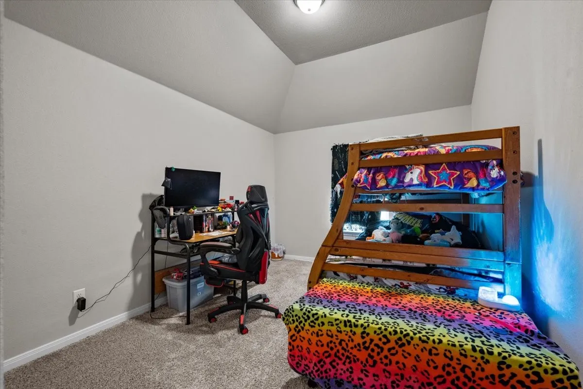 Carpeted office space with lofted ceiling and baseboards