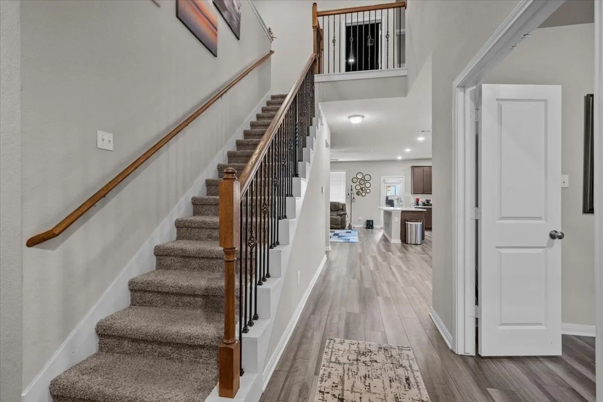 Staircase with wood finished floors and a high ceiling