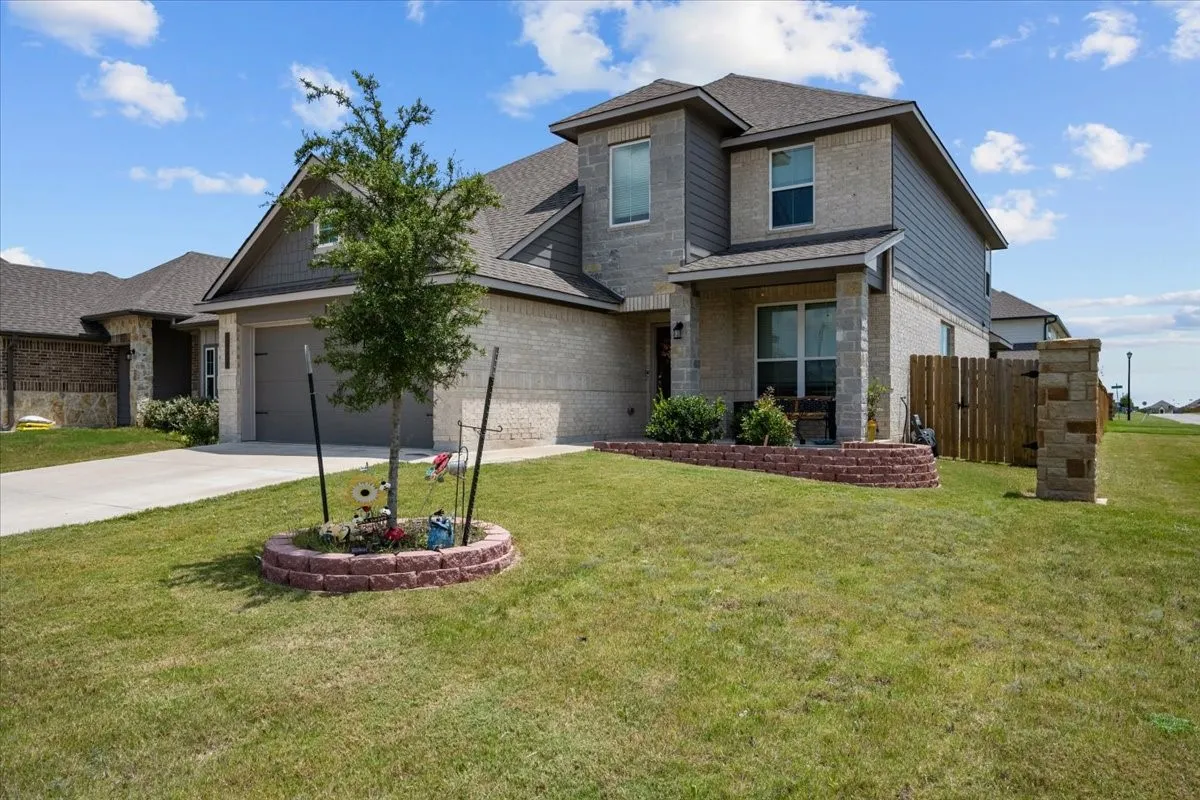 View of front of property with driveway, brick siding, an attached garage, and a shingled roof