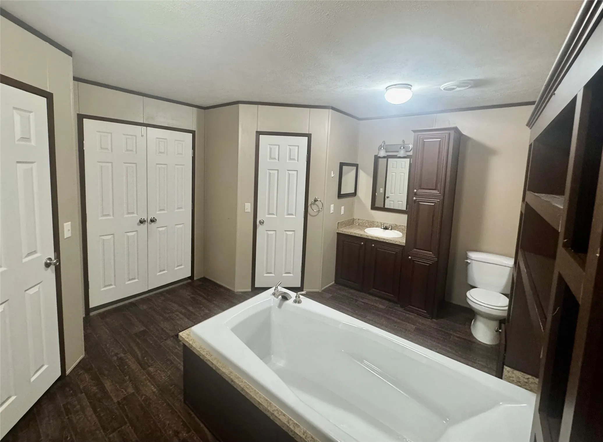 Ensuite bathroom with large soaking tub, dual sinks and vanities, dual walk in closets, separate shower, linen storage