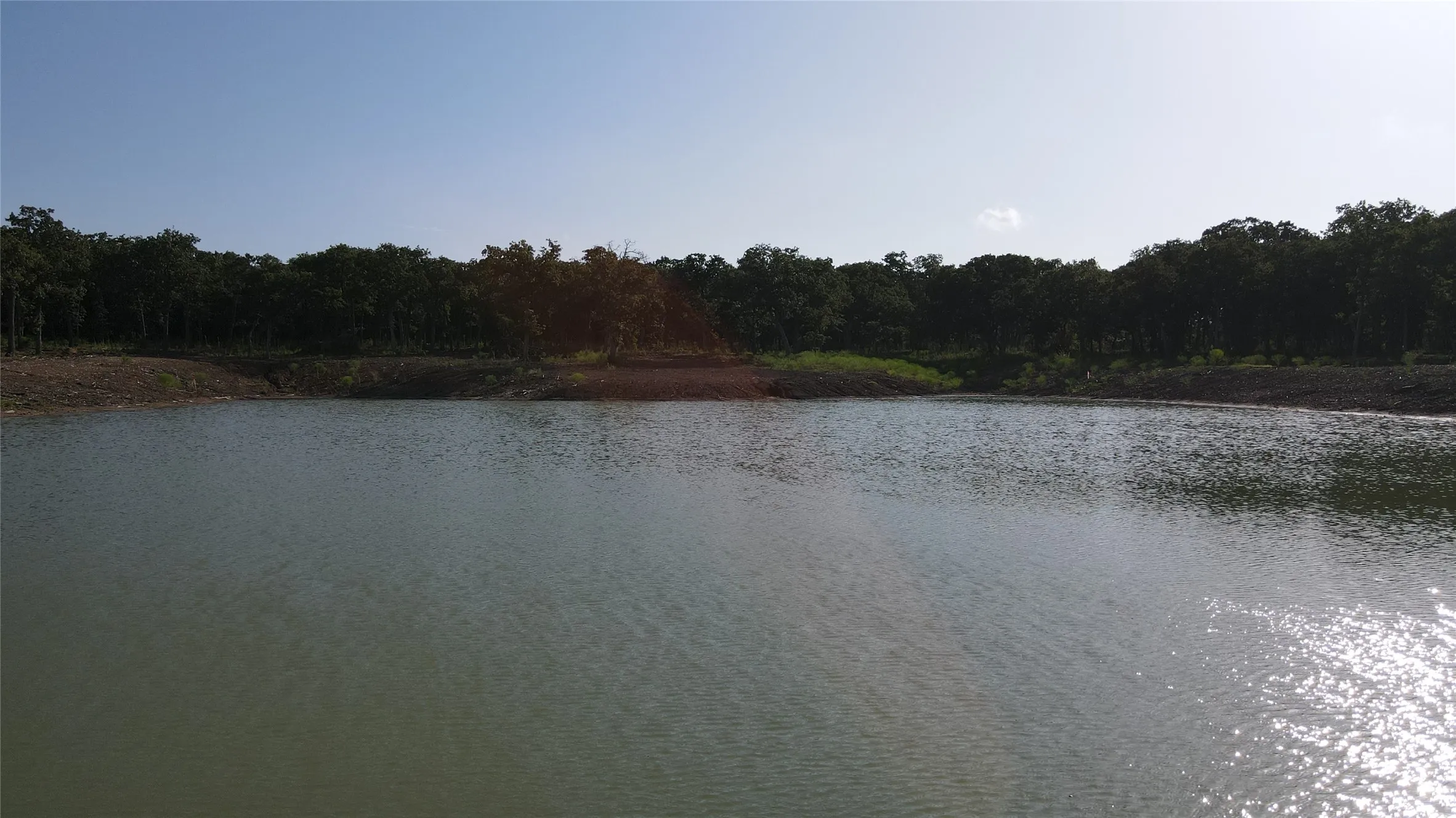 Water view with a heavily wooded area