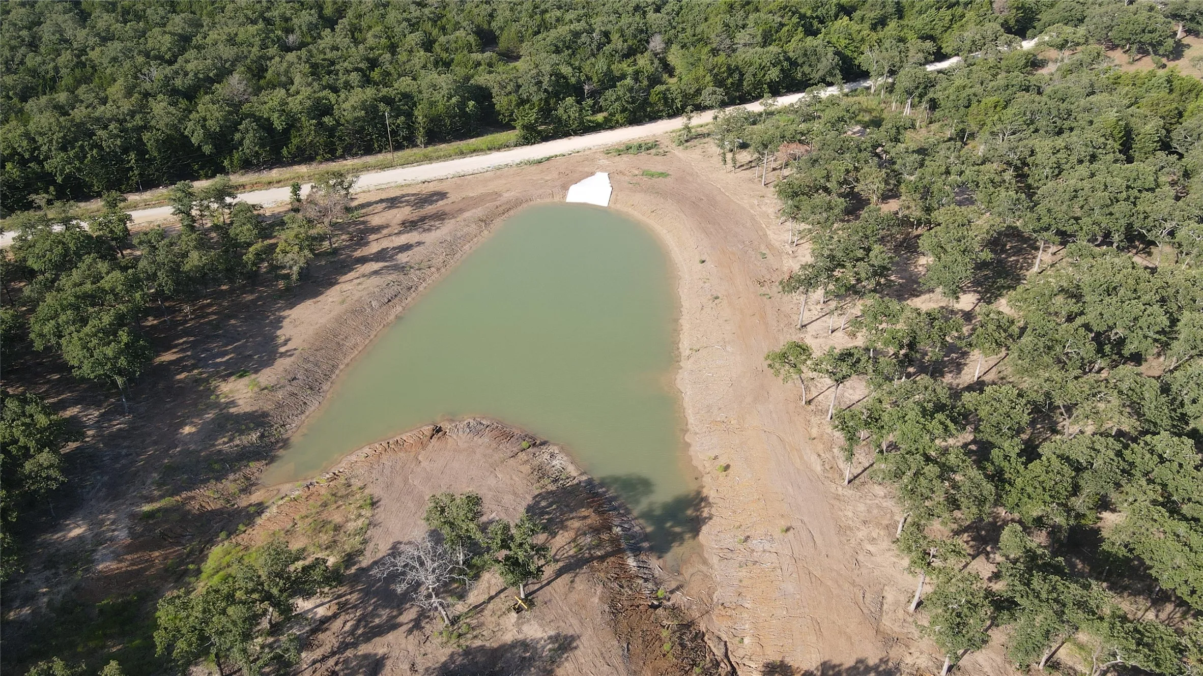 View of property location featuring a nearby body of water and a heavily wooded area