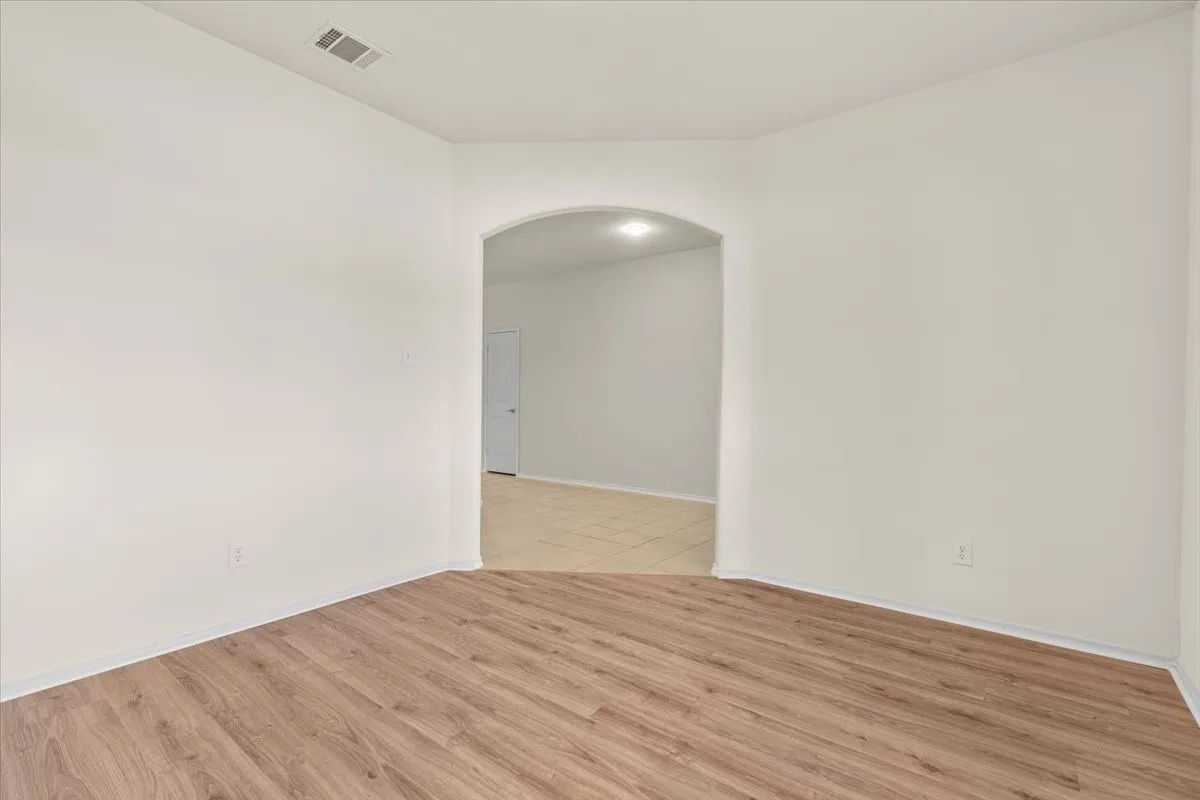 Spare room with light wood-style floors and arched walkways