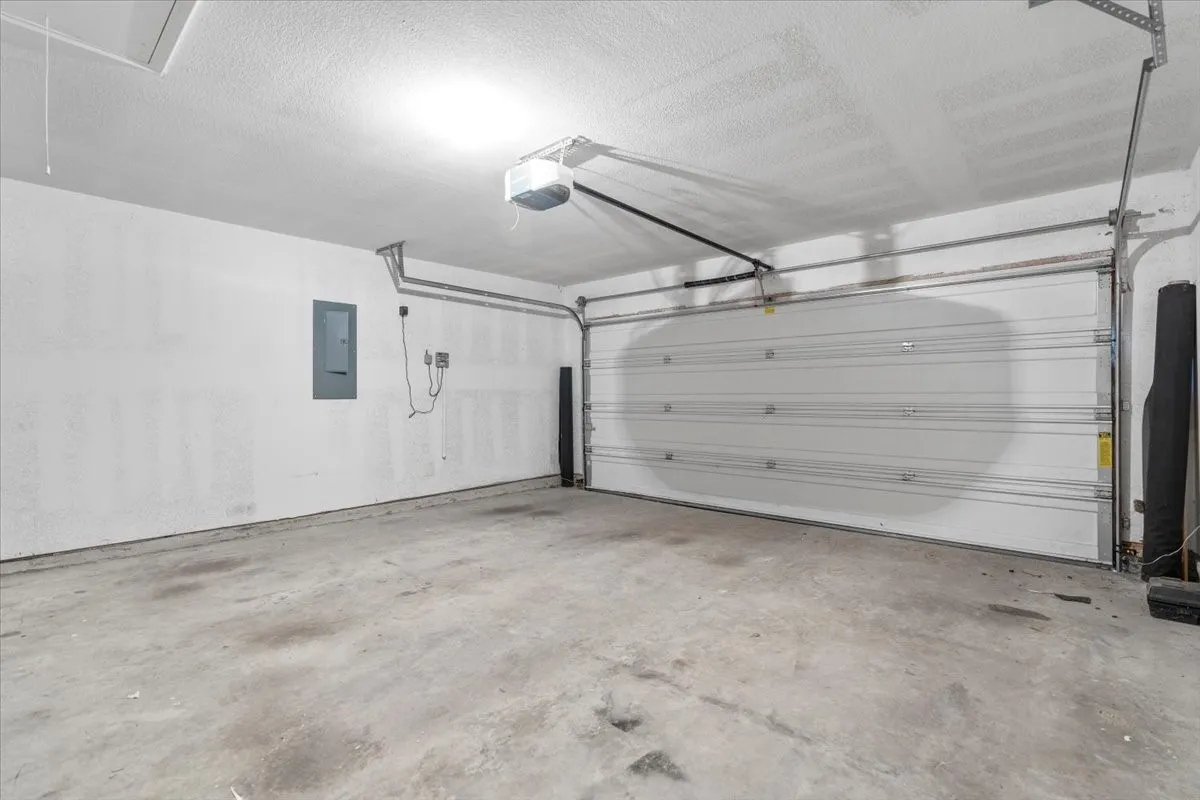 Garage featuring electric panel and a garage door opener