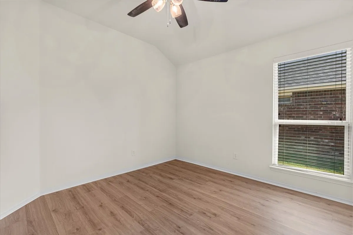 Empty room featuring wood finished floors and ceiling fan