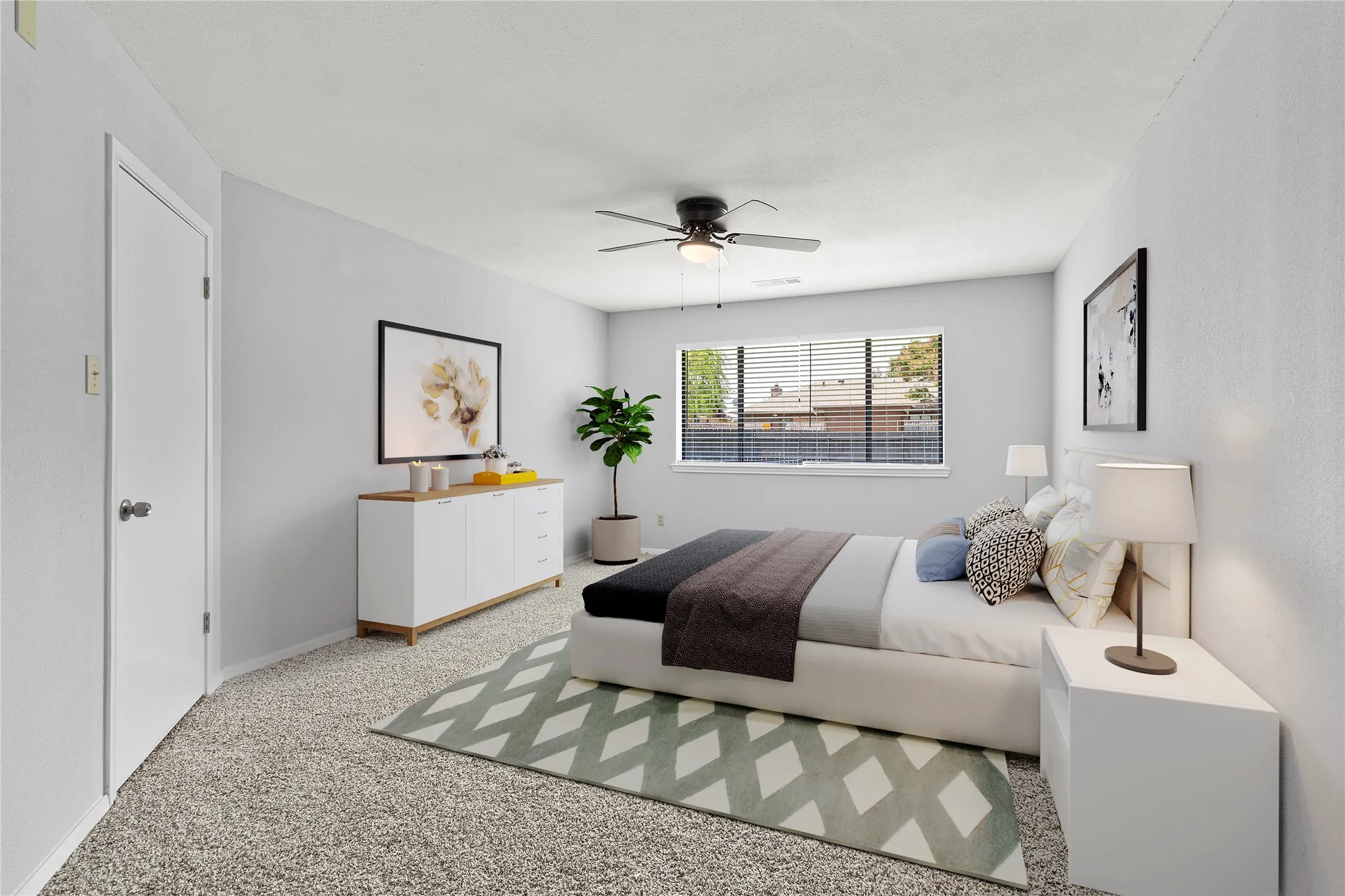 Bedroom with ceiling fan and speckle patterned floor