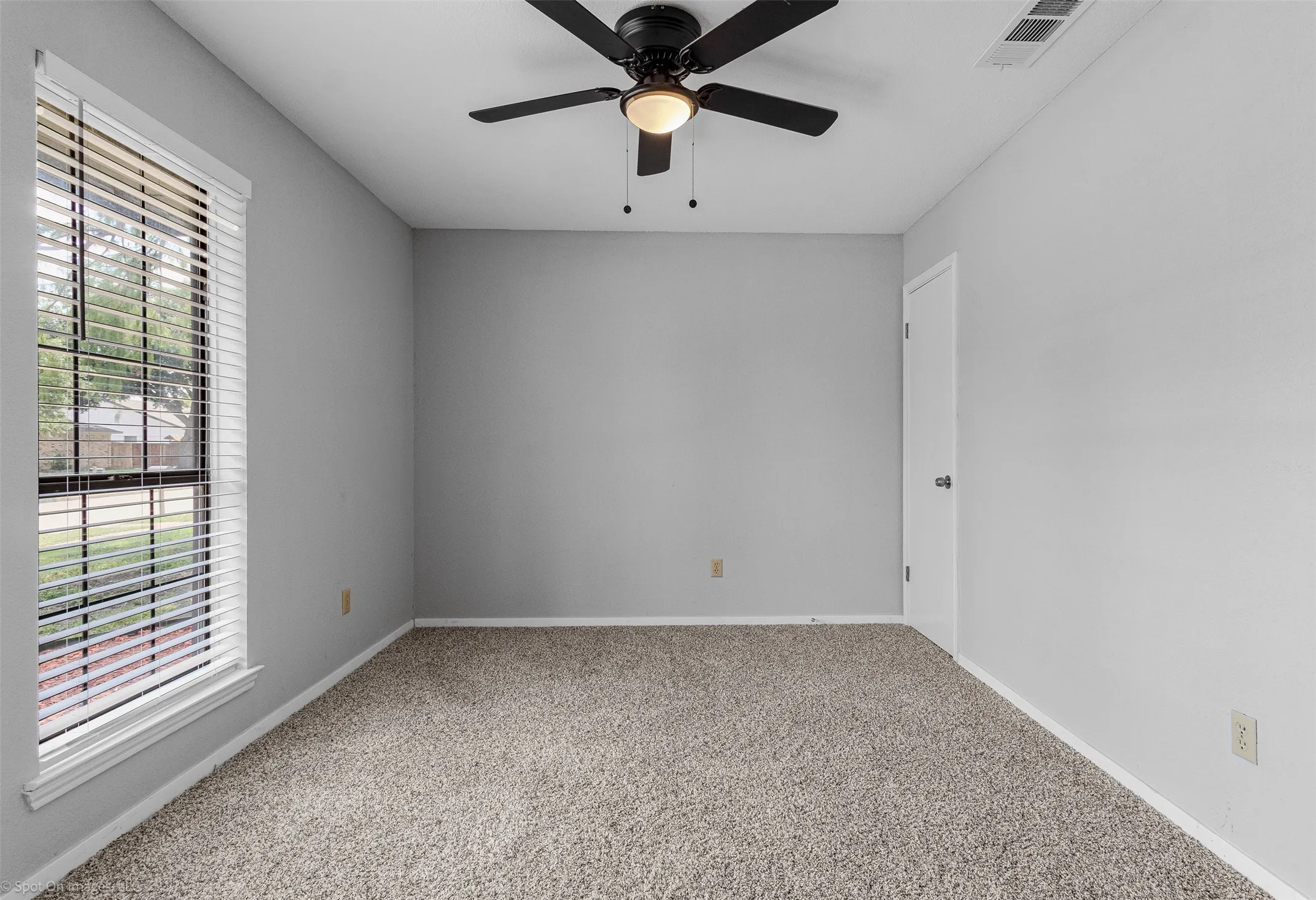Spare room featuring a ceiling fan and carpet