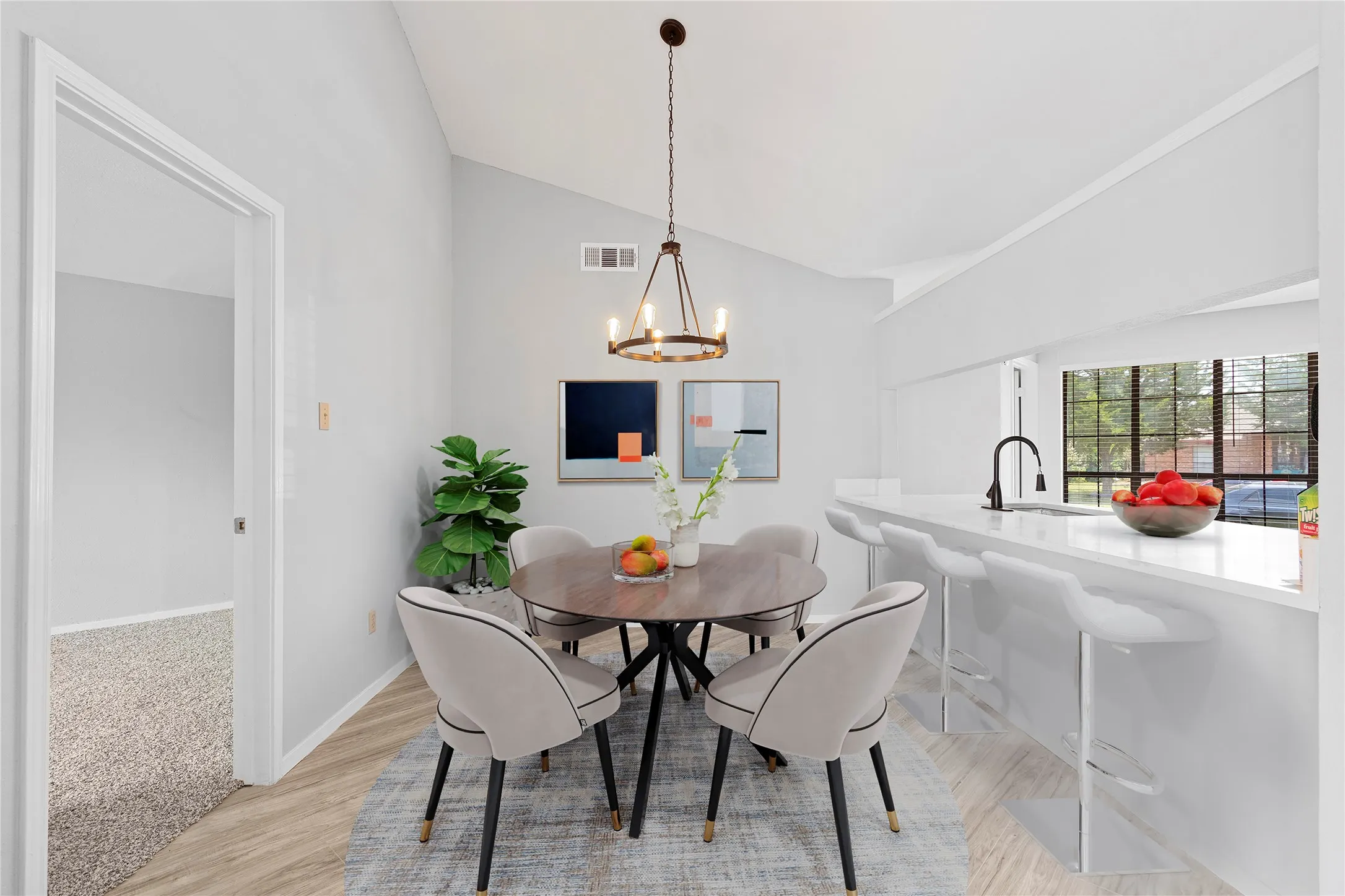 Dining space with lofted ceiling, light wood-style floors, and a chandelier