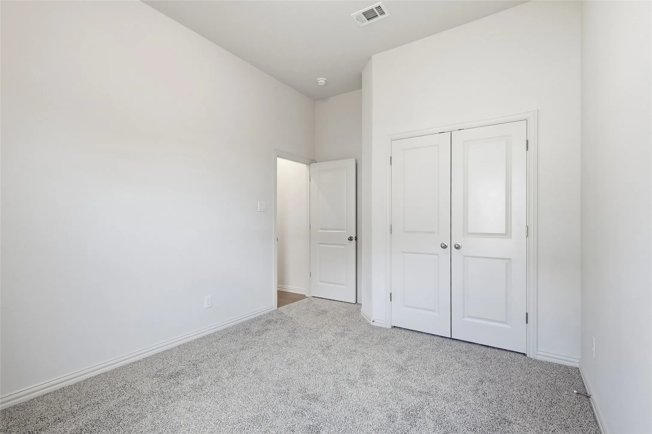 Unfurnished bedroom featuring light colored carpet and a closet