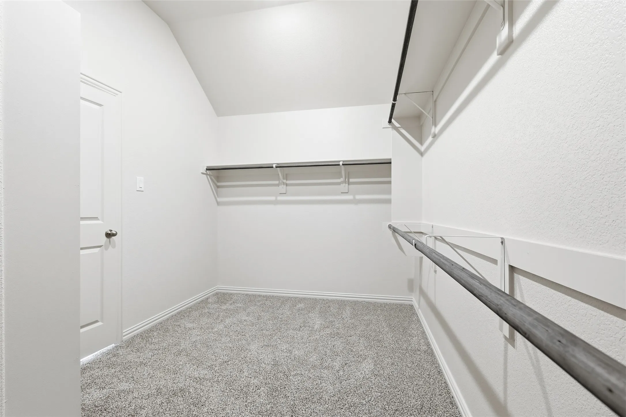 Spacious closet featuring light colored carpet and lofted ceiling