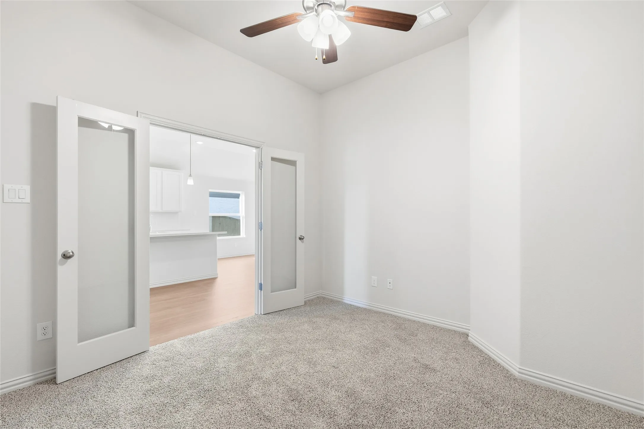 Unfurnished bedroom with light colored carpet and ceiling fan