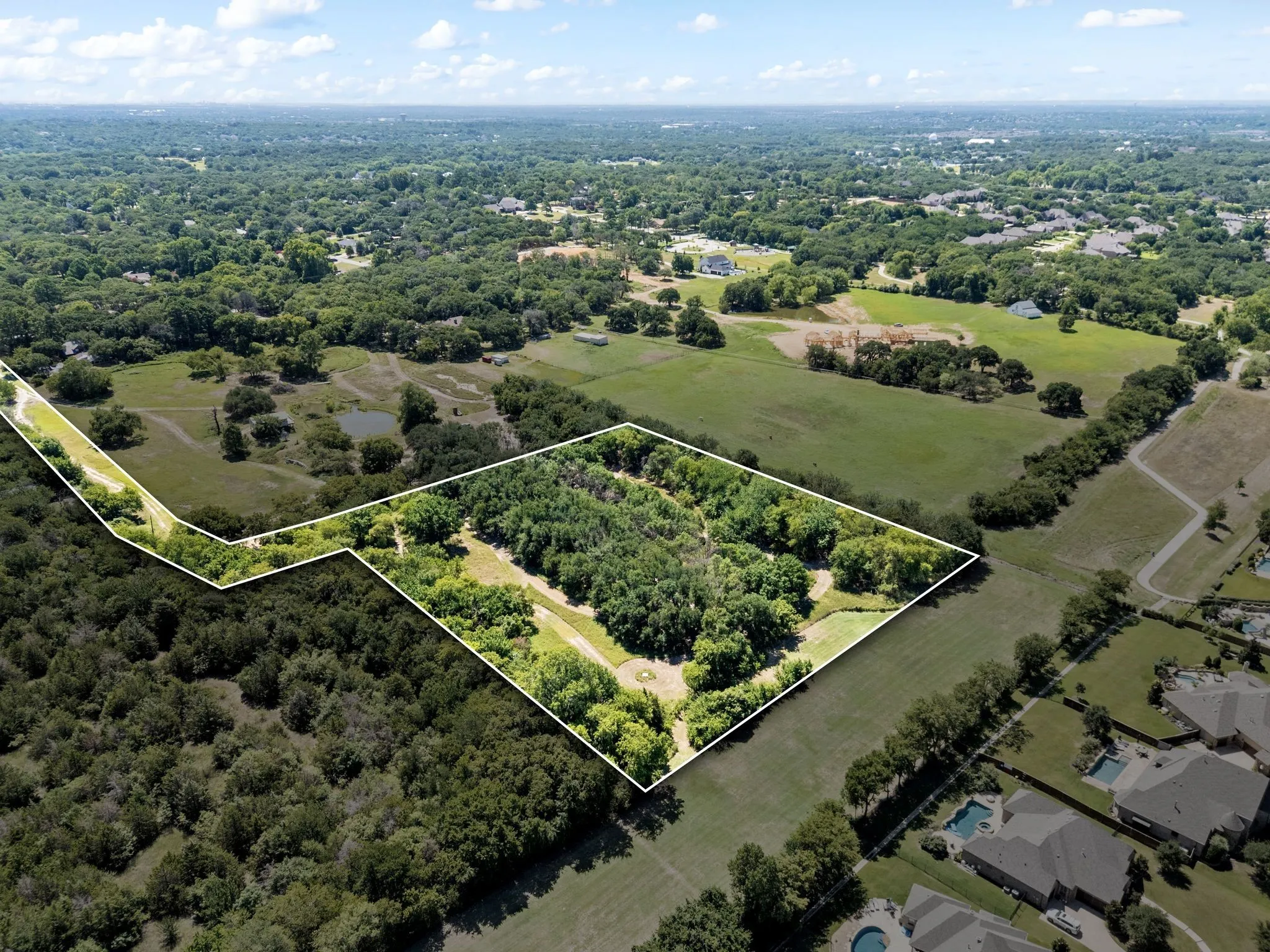 Aerial view of property's location with property boundaries highlighted and a heavily wooded area
