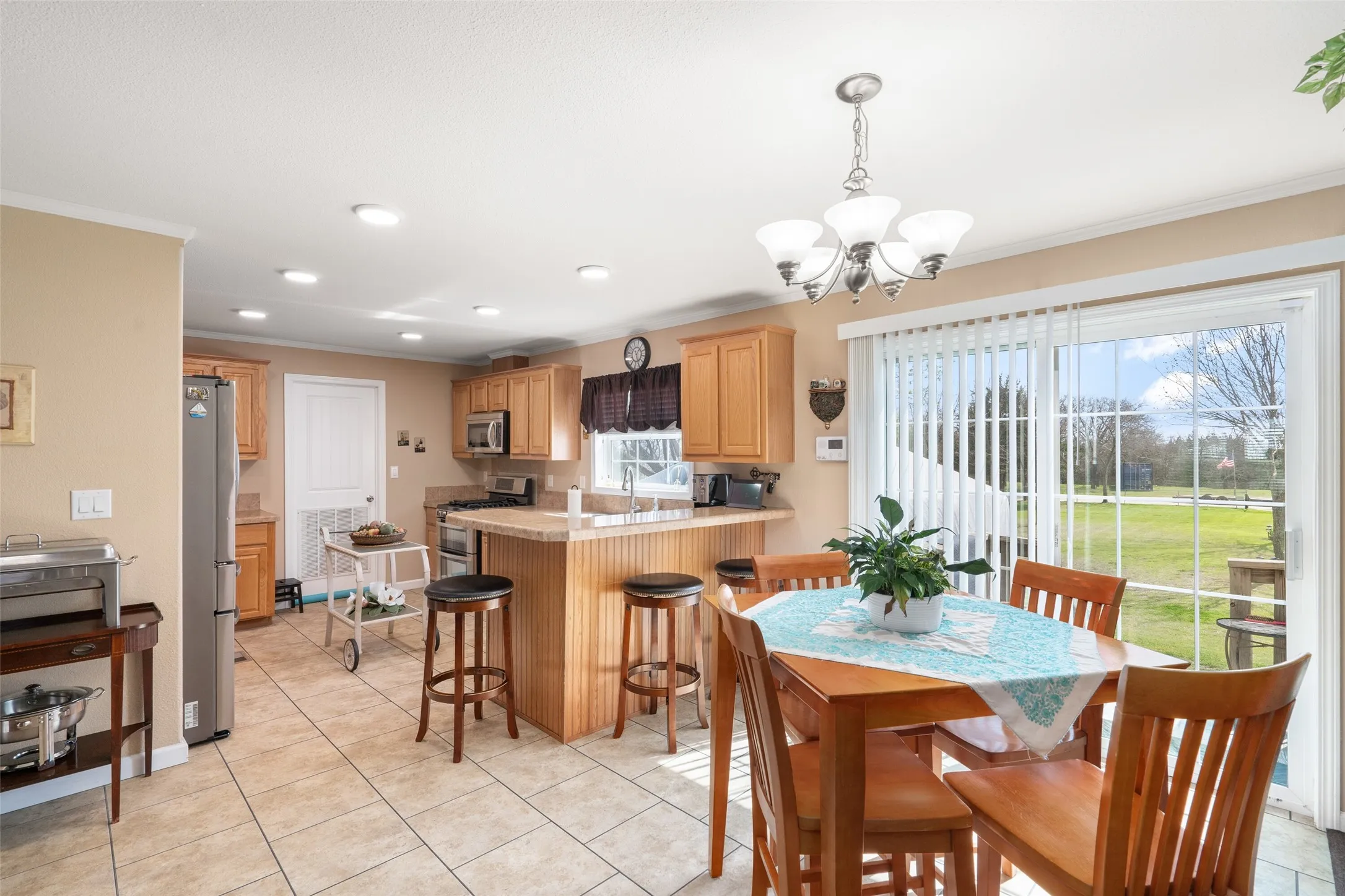 Dining area with light tile patterned flooring, recessed lighting, and a chandelier