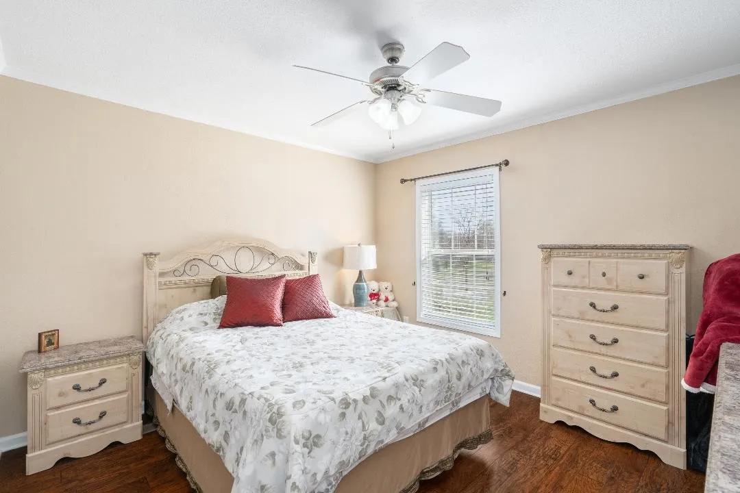 Bedroom with crown molding, dark wood-type flooring, and ceiling fan