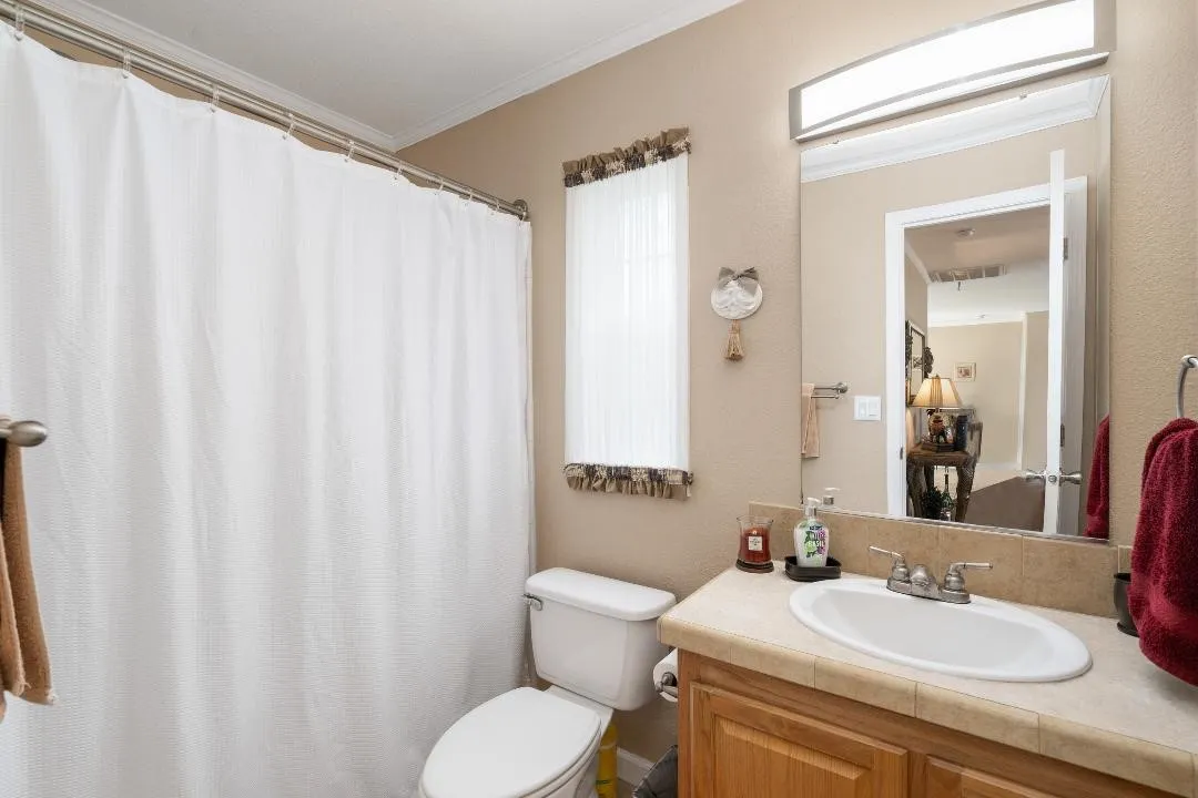Bathroom featuring vanity, ornamental molding, a textured wall, and curtained shower