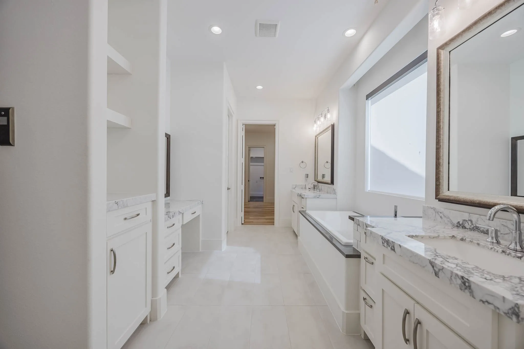 Full bath featuring two vanities, recessed lighting, a bath, and light tile patterned floors