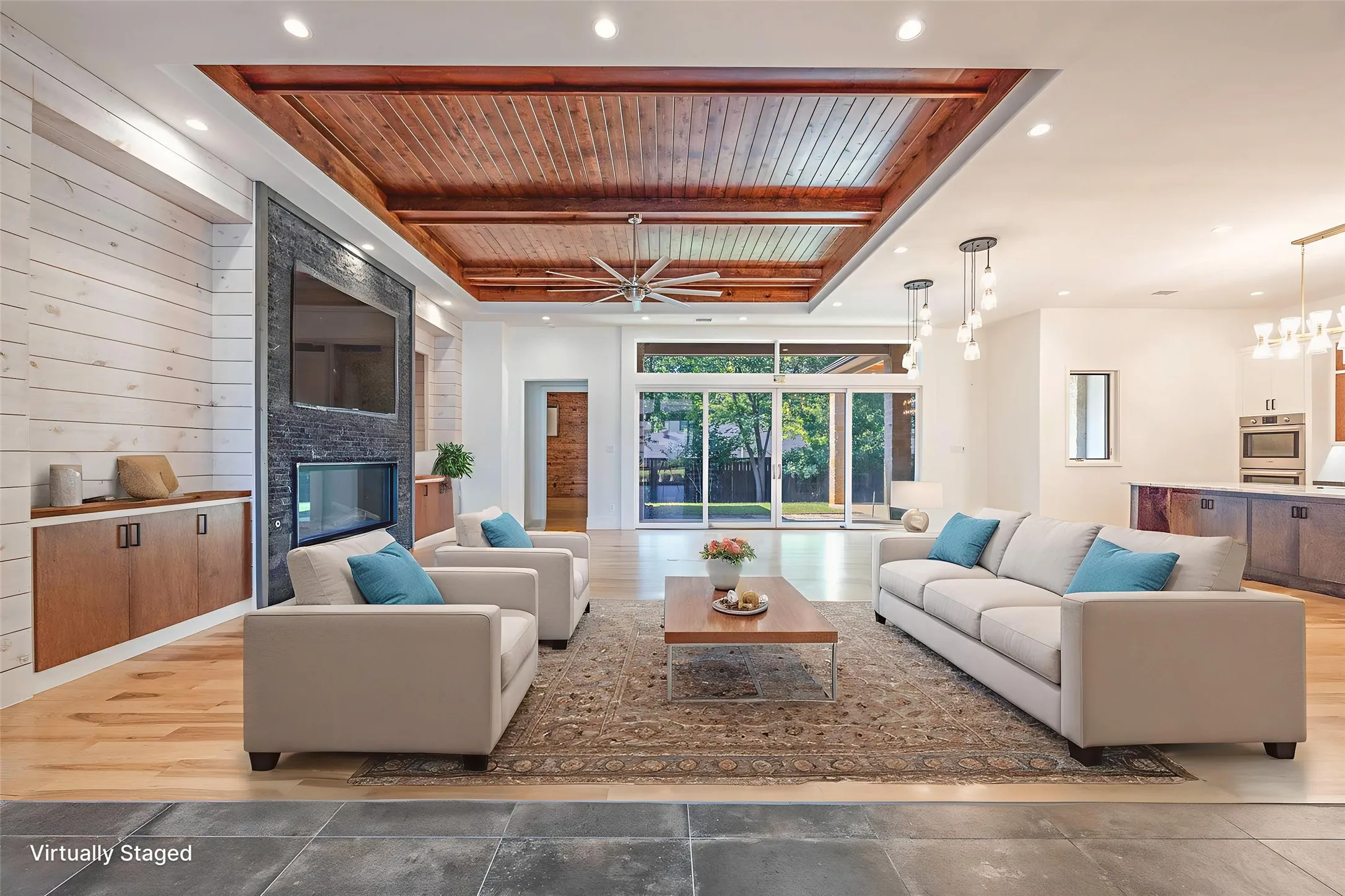 Living room with a fireplace, a wooden ceiling with exposed beams, recessed lighting, ceiling fan, and wooden walls