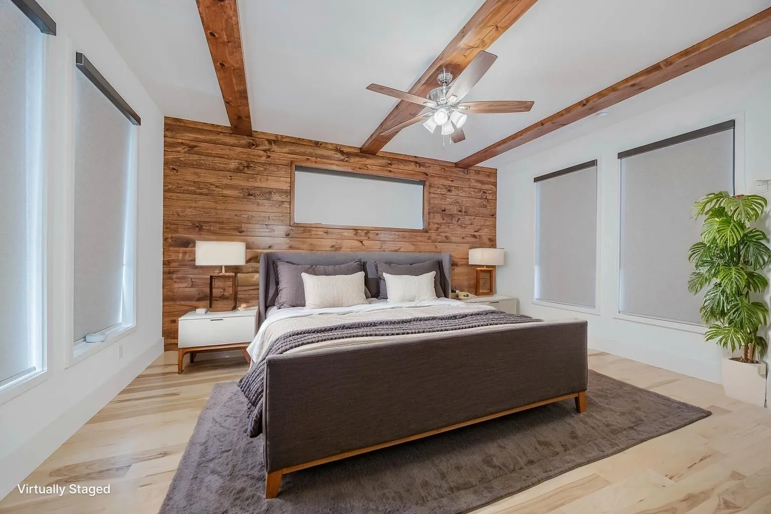 Bedroom featuring wooden walls, beam ceiling, a ceiling fan, and light wood-style floors