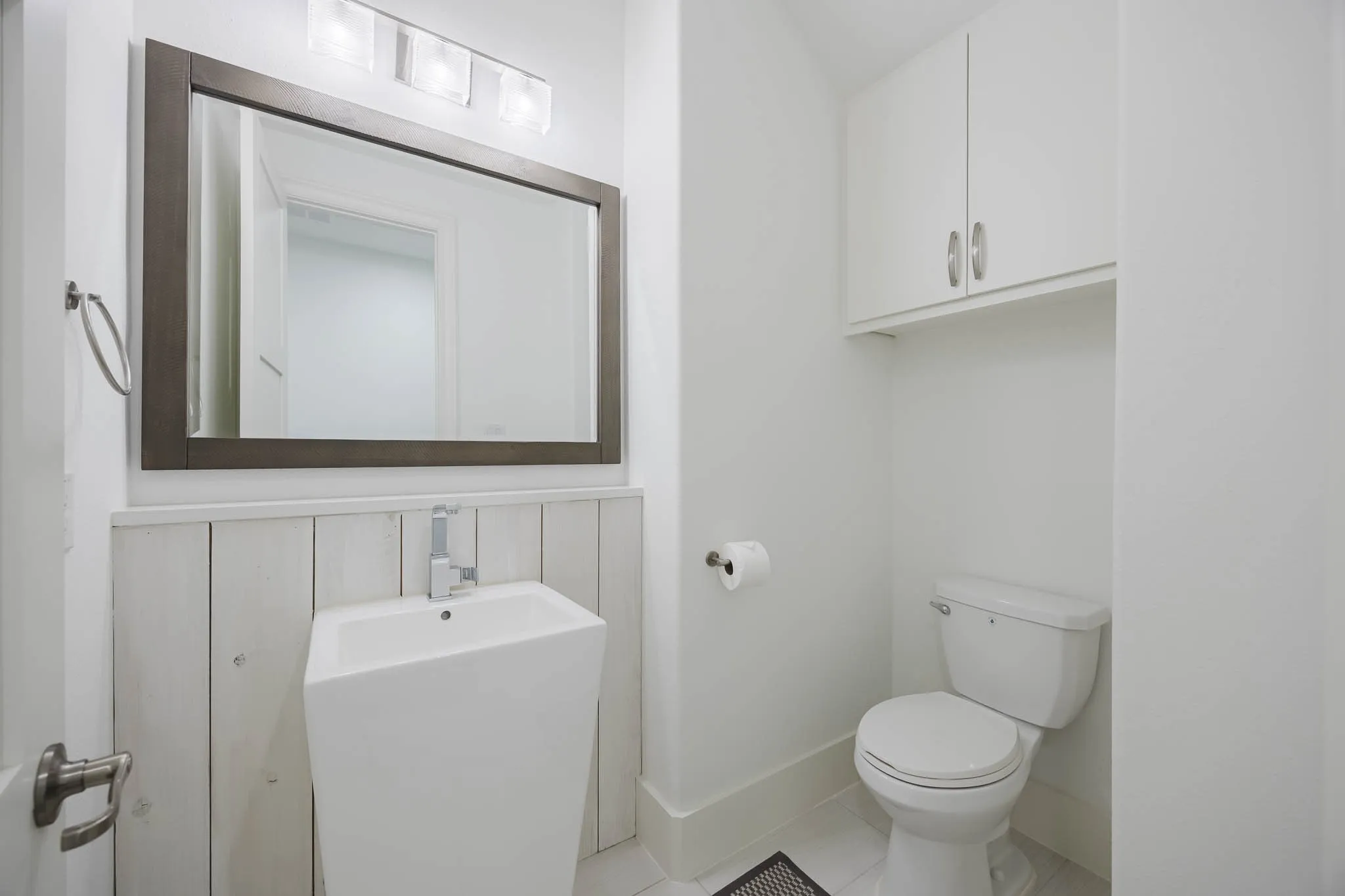 Half bath with tile patterned flooring and toilet
