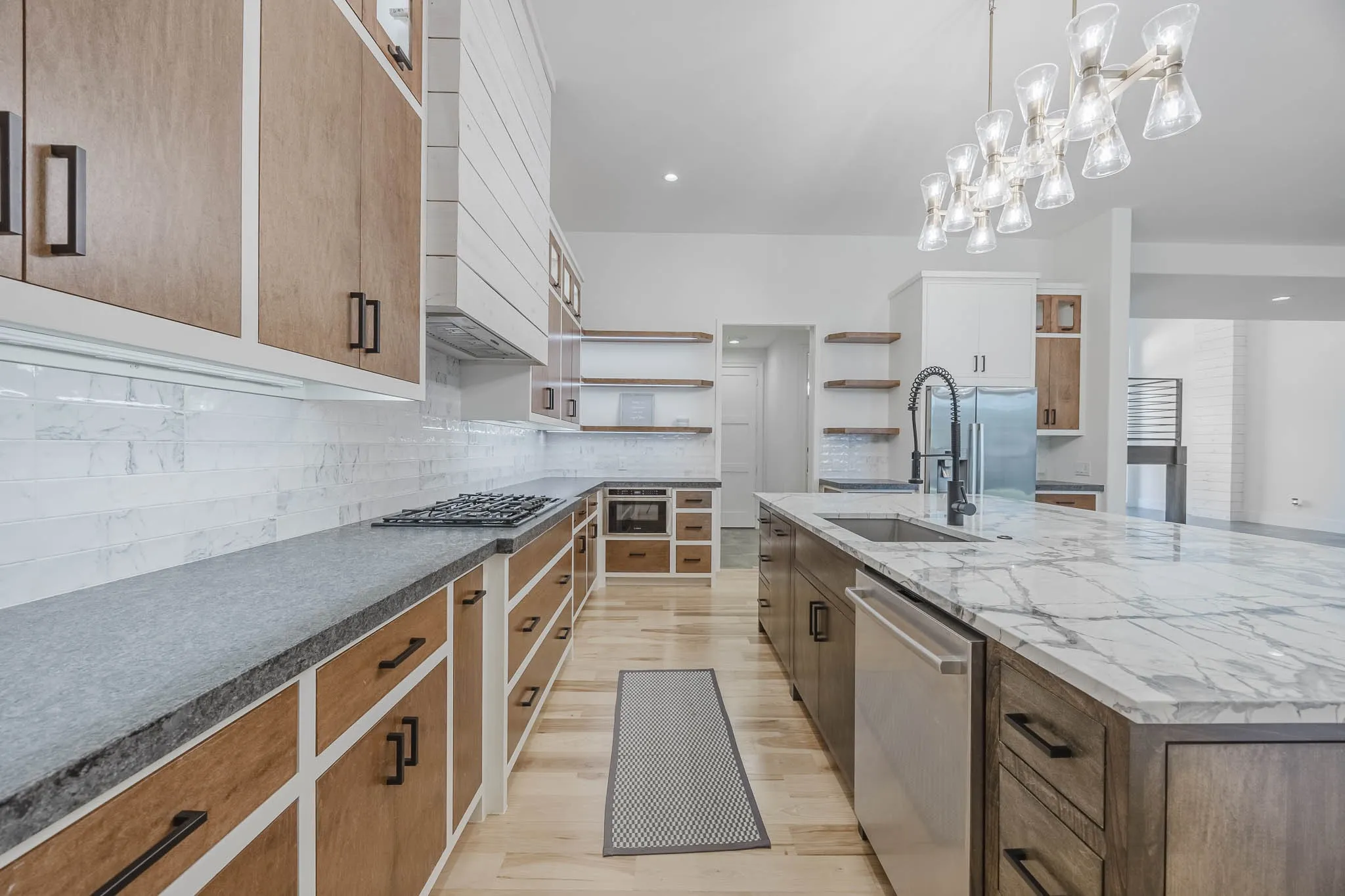 Kitchen featuring tasteful backsplash, stainless steel appliances, light wood-style floors, recessed lighting, and a large island