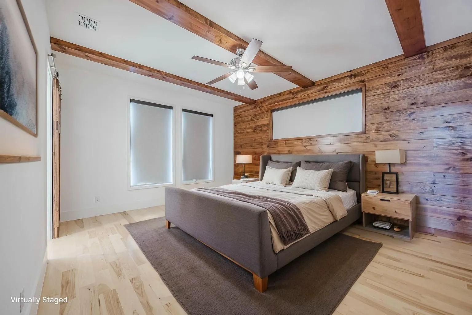 Bedroom featuring wooden walls, beamed ceiling, light wood-style flooring, and ceiling fan
