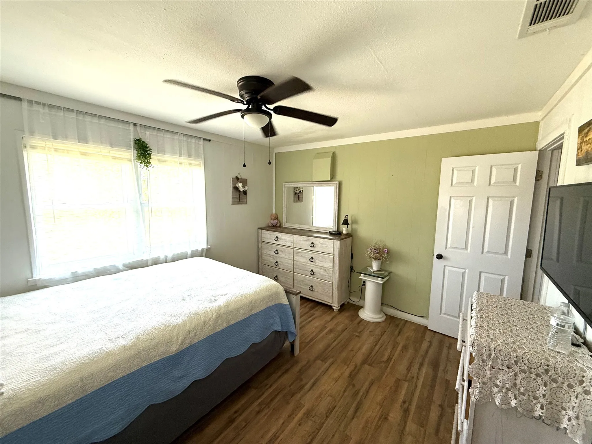 Bedroom featuring dark wood-style floors, ceiling fan, a textured ceiling, and ornamental molding