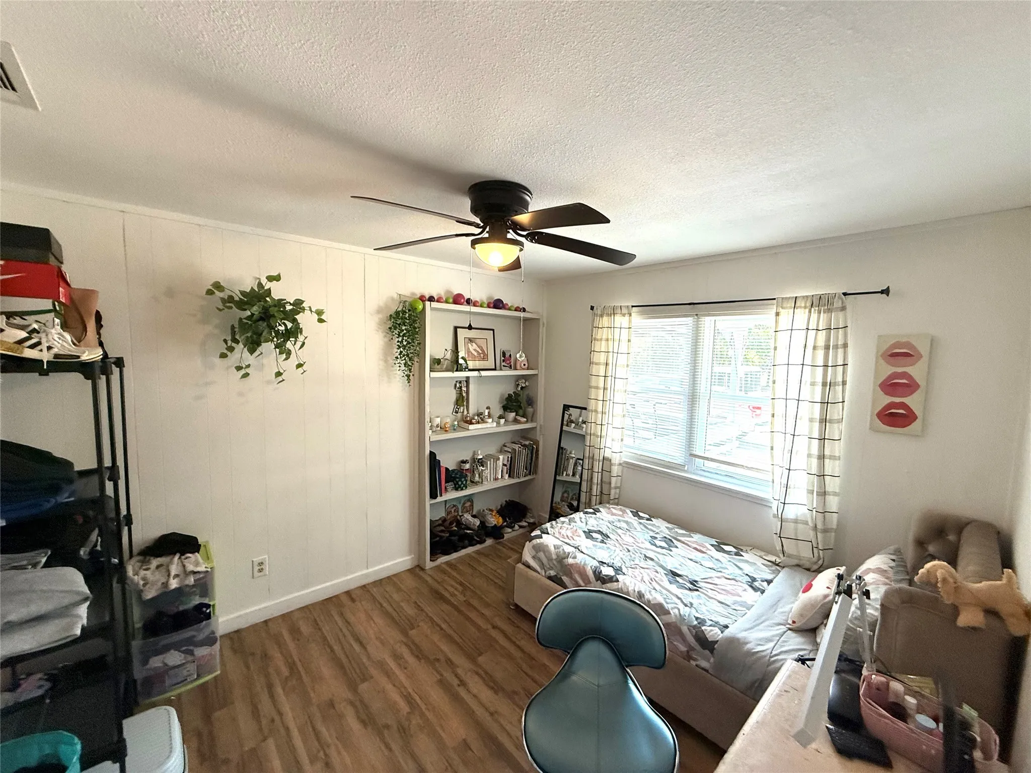 Bedroom featuring wood finished floors, a textured ceiling, and ceiling fan