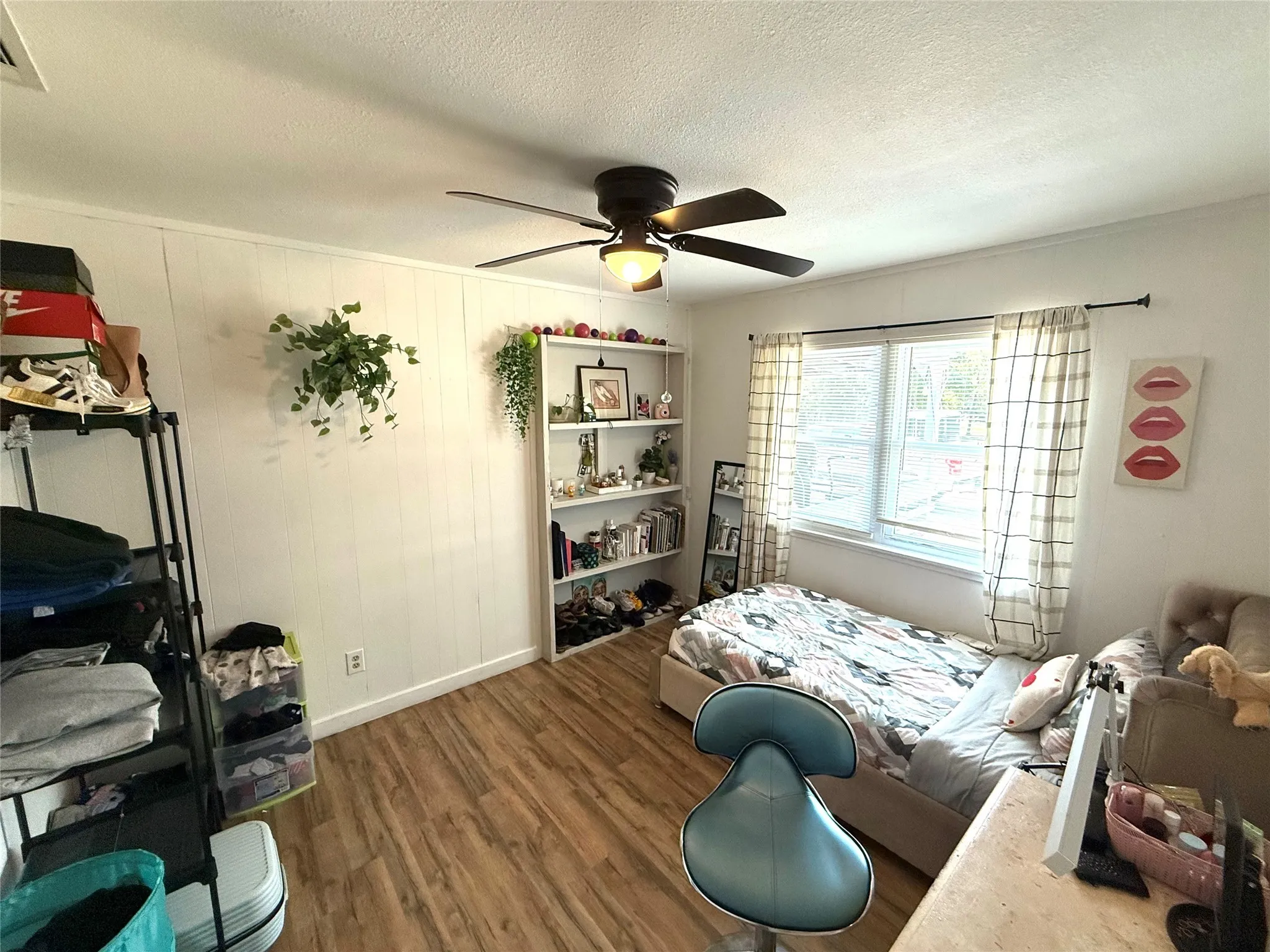 Bedroom featuring wood finished floors, a textured ceiling, and ceiling fan