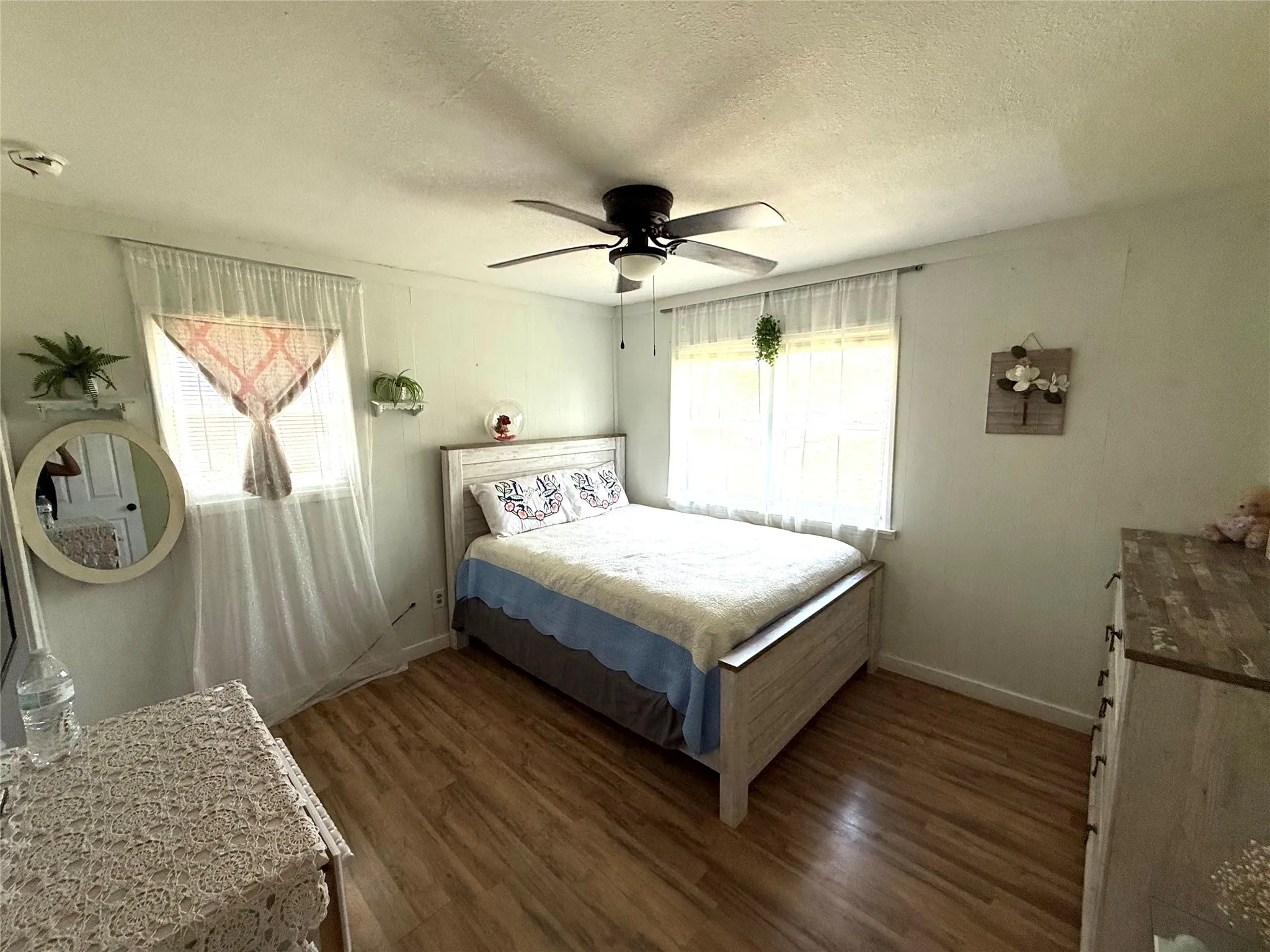 Bedroom featuring a textured ceiling, dark wood-type flooring, and a ceiling fan