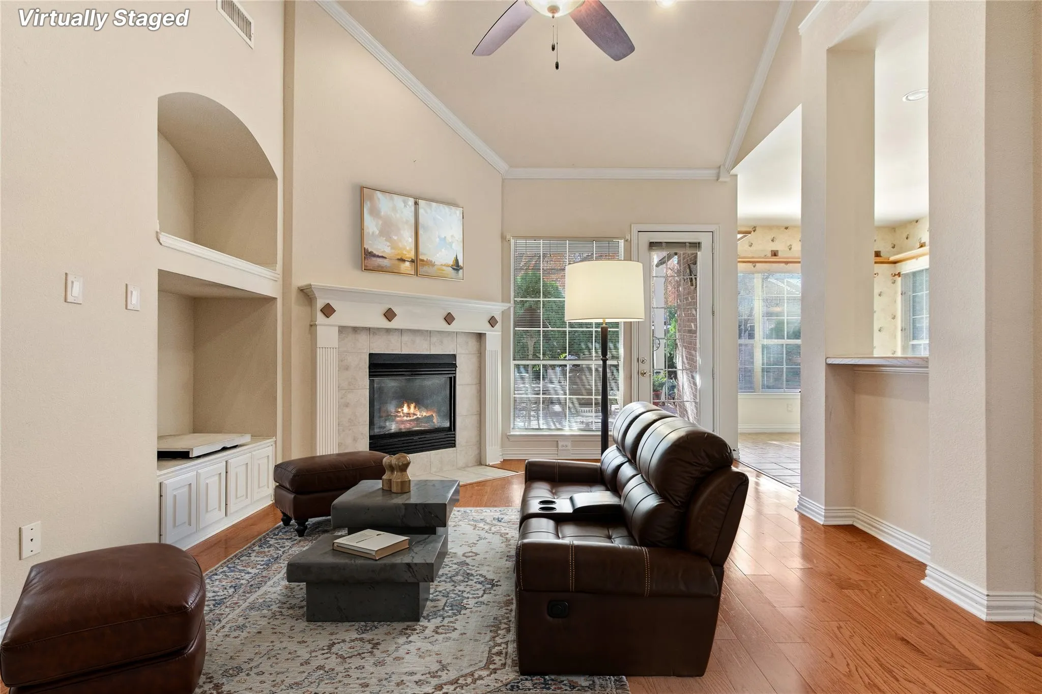 Living space featuring vaulted ceilings, a ceiling fan, and wood-finish flooring