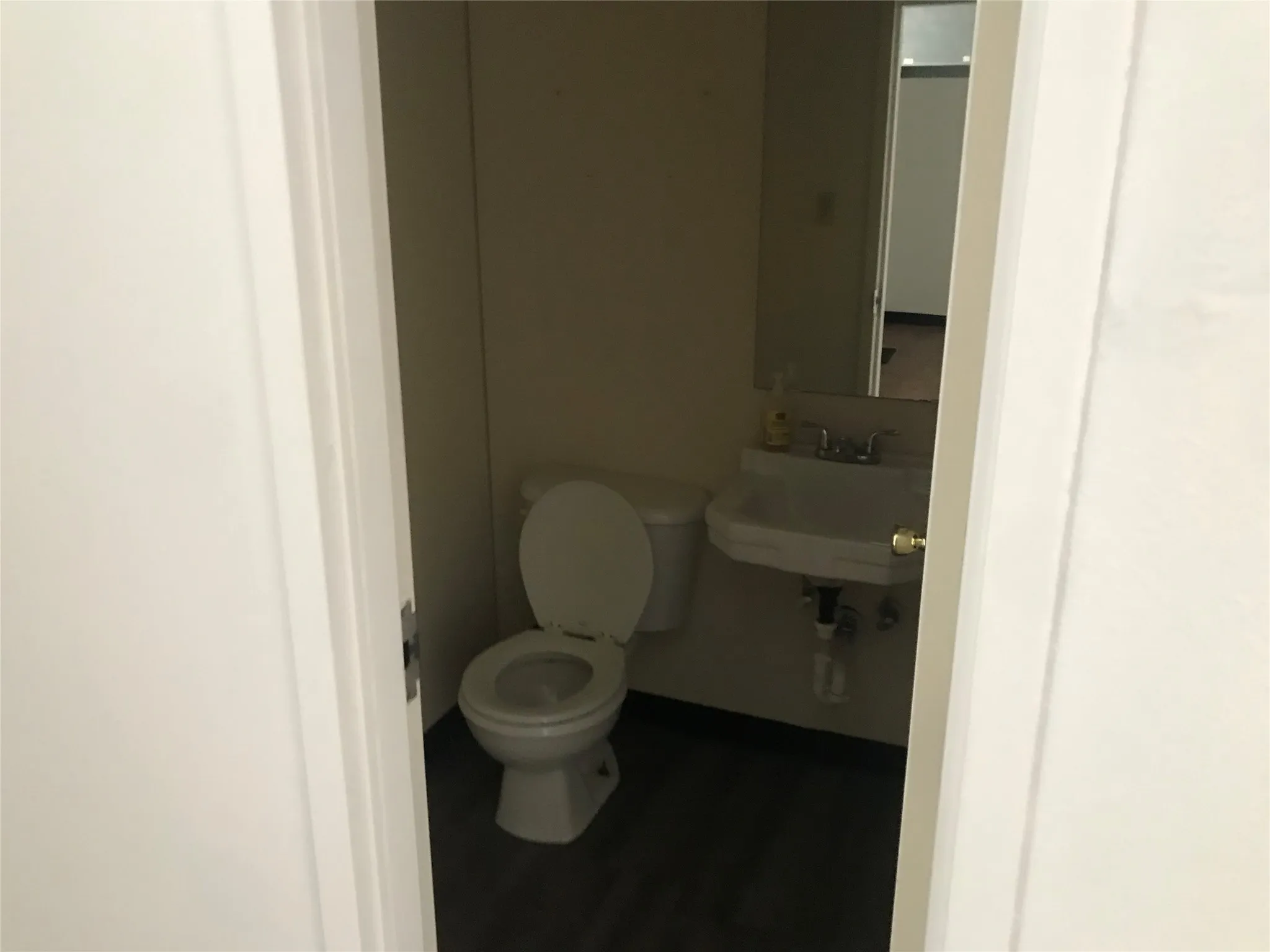 Half bath with toilet and wood finished floors